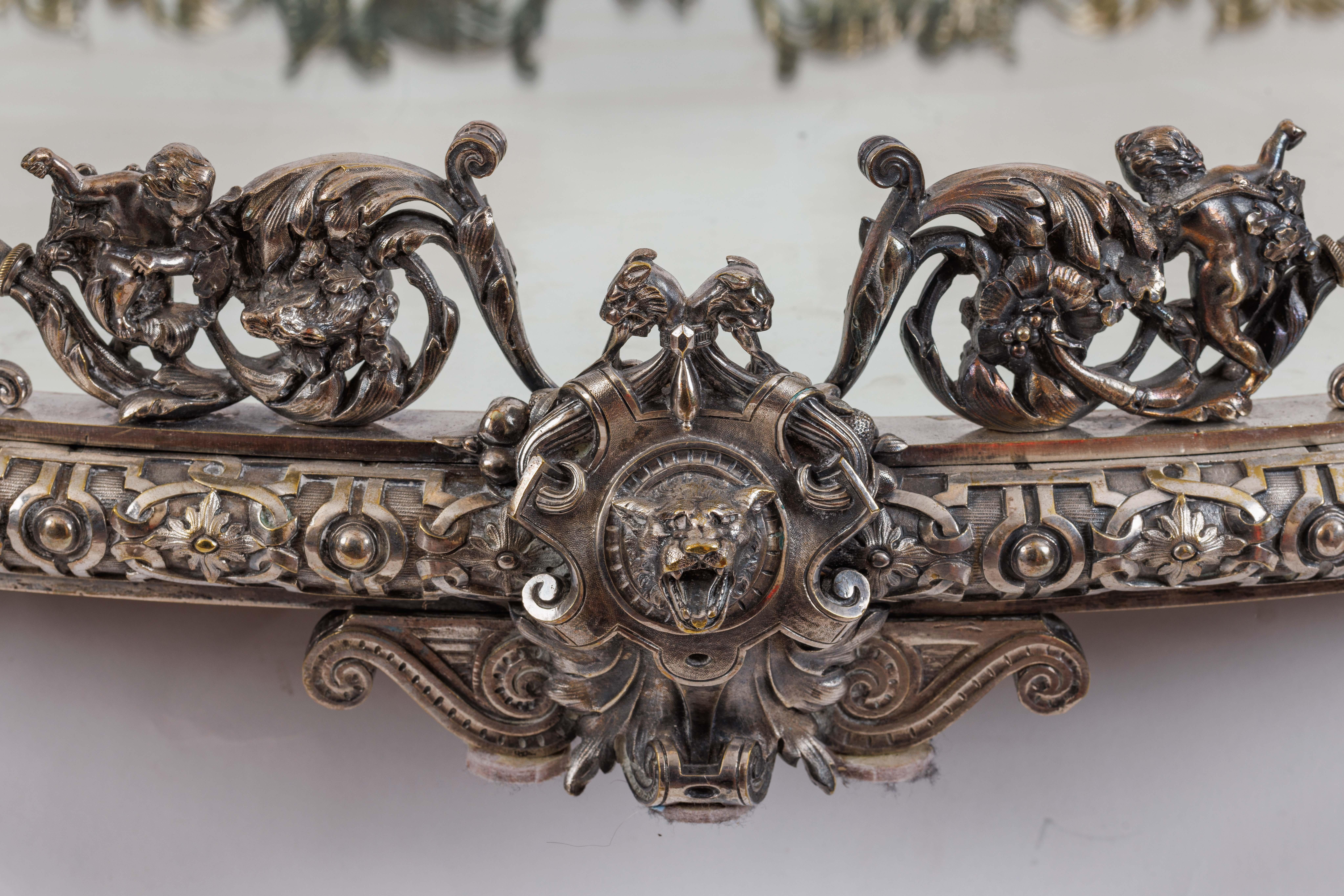 Massif Napoléon III français en bronze argenté et miroir Surtout de Table Plateau, vers 1870

Plongez dans le monde complexe des chérubins, tandis que des figures délicates et enchanteresses dansent autour du périmètre, ajoutant une touche éthérée