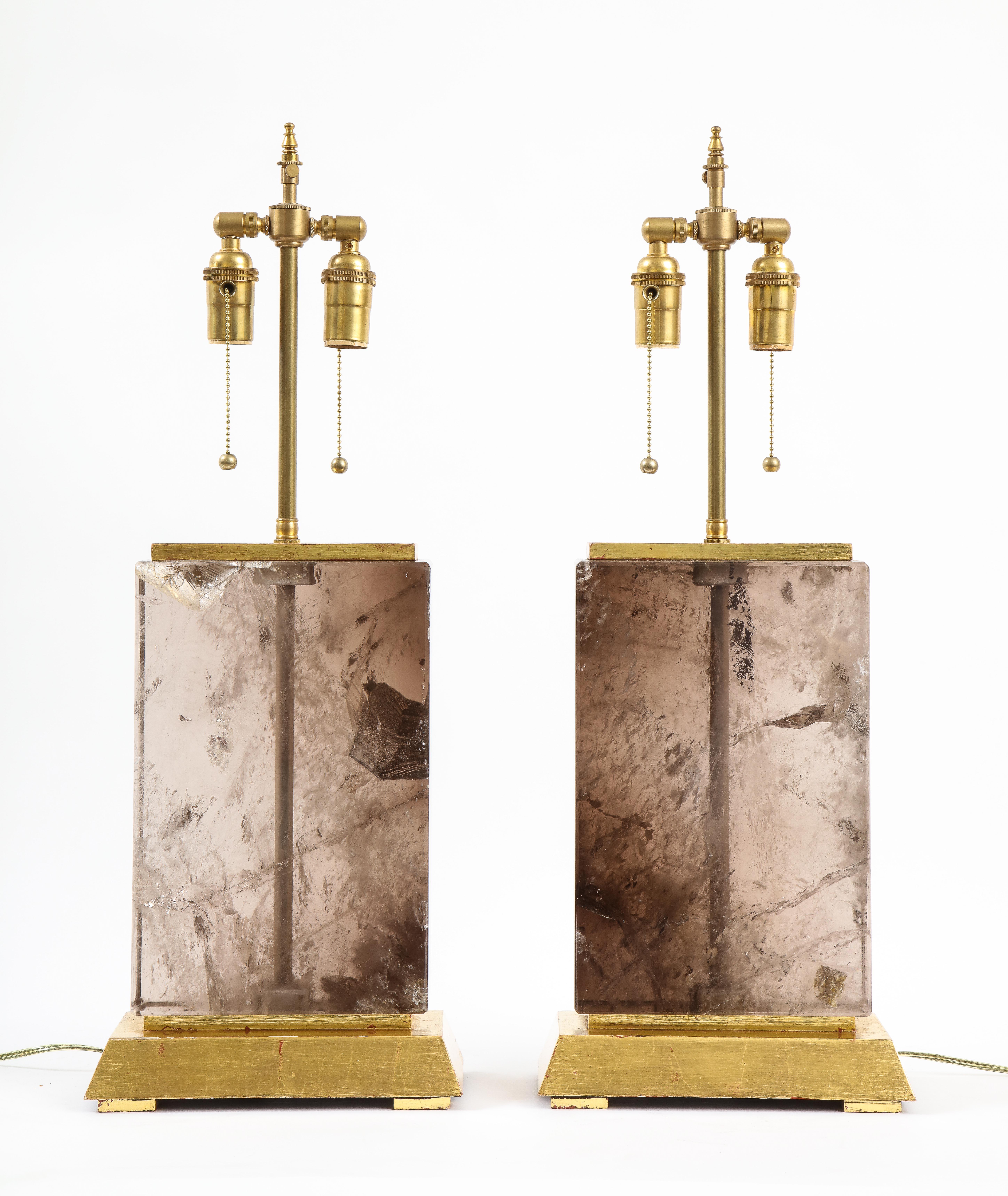 A massive pair of French Natural smokey rock crystal rectangular form lamps with gilt rectangular wood bases. These are truly a gorgeous pair of lamps, with hand-carved and hand-polished smoky rock crystal bodies, each carved out of a single large