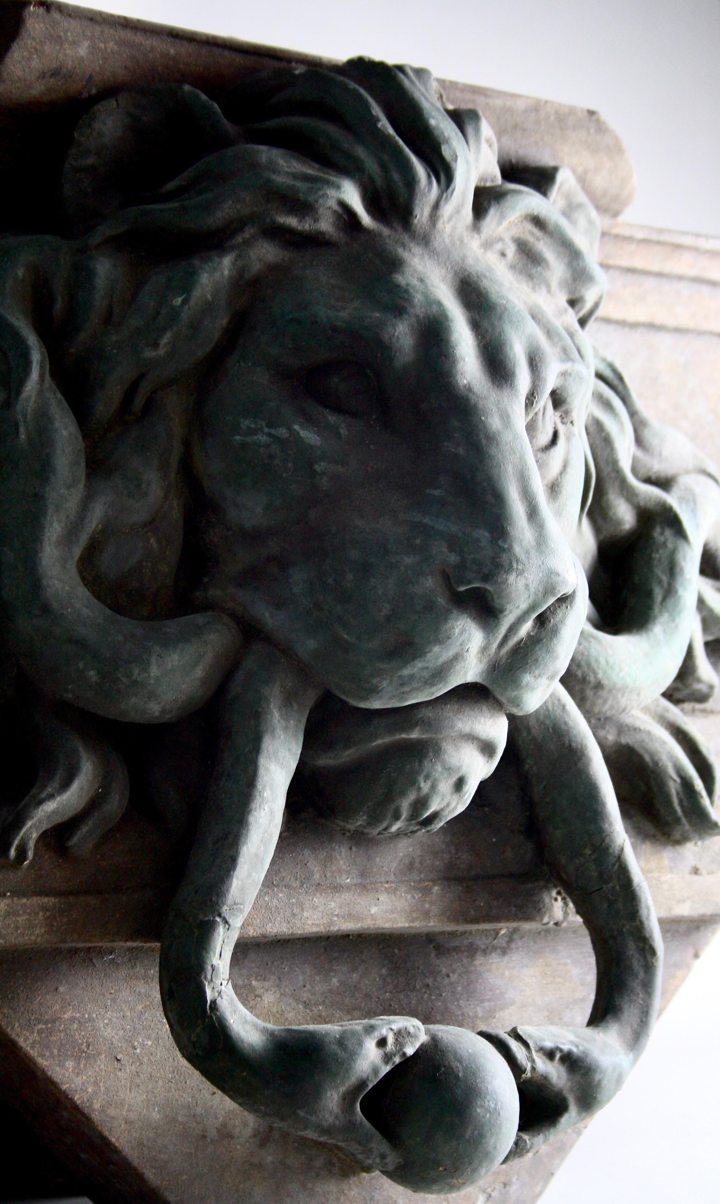 Modelled as a lion mask door knocker with entwined serpents, centred on a rectangular moulded architrave. This architectural element was designed to sit above the inner entrance doorway of a large house.
