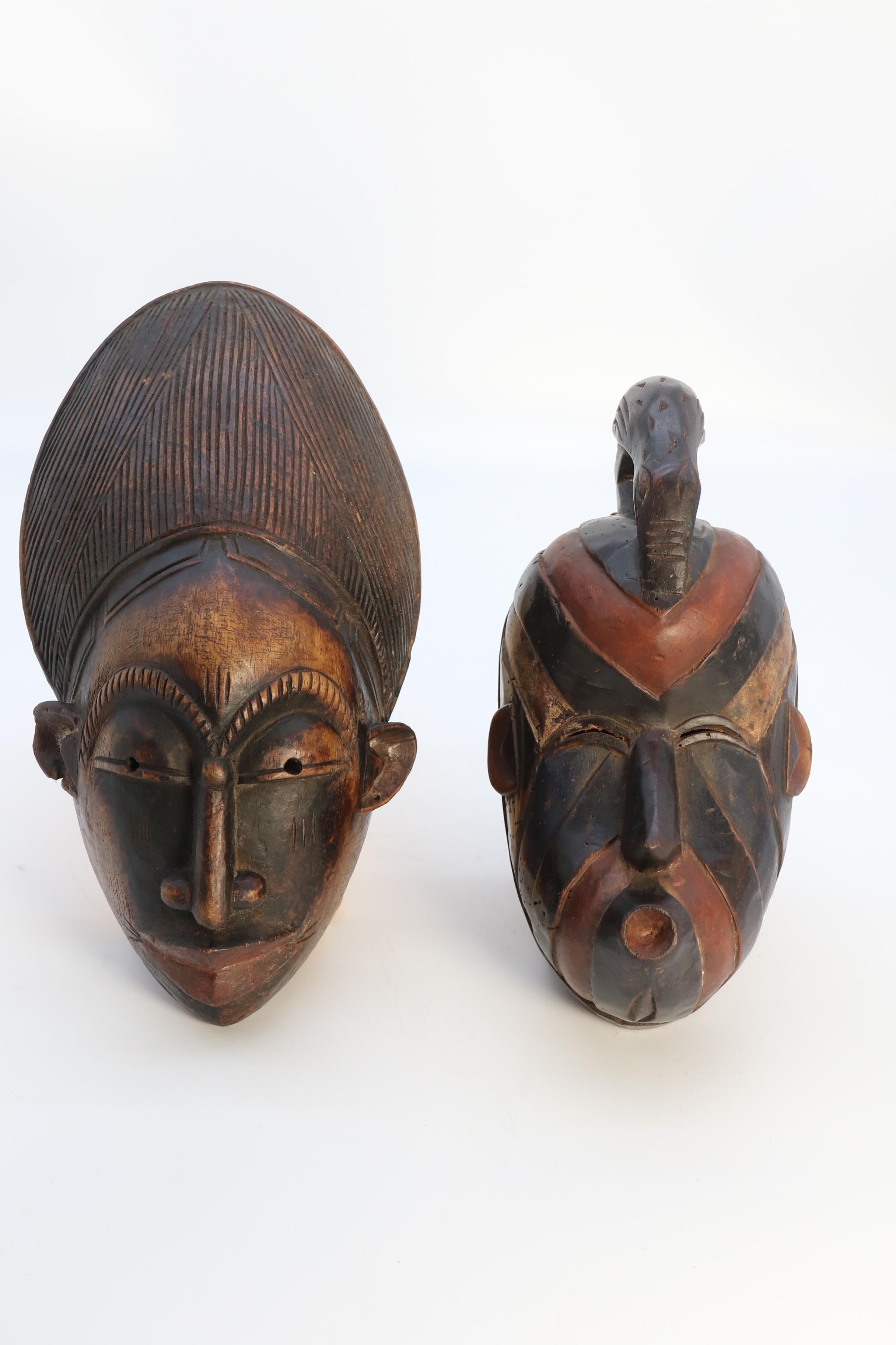 A most interesting and decorative matched pair of African tribal carved wooden face masks which were often used in ceremonial dance. The exaggerated and stylised features were designed to draw the attention of shock together with their primitive