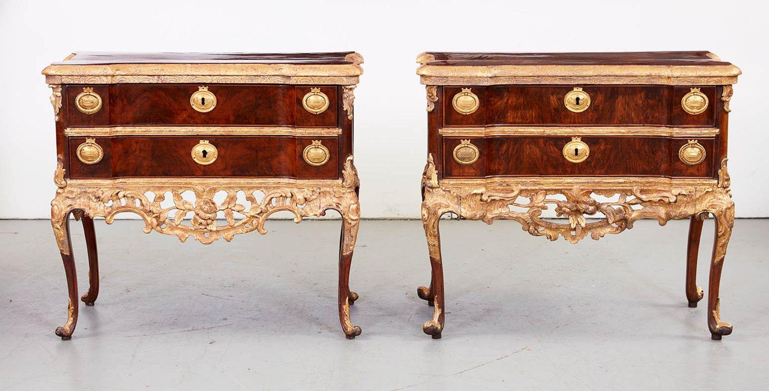 A Pair of Altona Walnut and Gilt Commodes Attributed to Johann Friedrich Köster
 
A fine pair of transitional commodes in walnut and giltwood, the walnut tops with crossbanding and carved giltwood molded edge over shaped drawers with giltwood