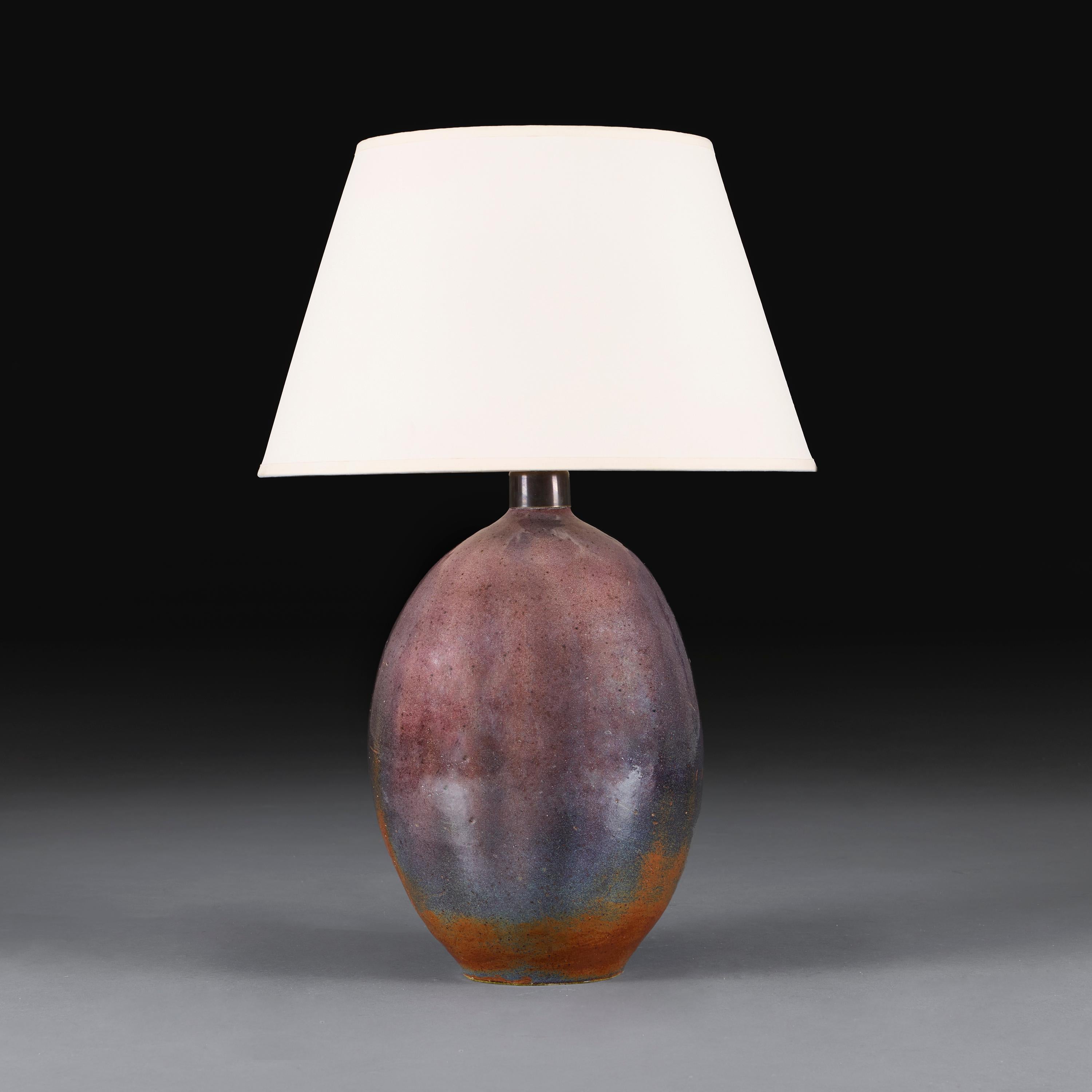France, circa 1960.

An oval form earthenware art pottery vase, decorated with a mauve purple lustre glaze, now mounted as a lamp.

Height 36.00 centimetres.
Height with shade 61.00 centimetres.
Diameter 24.00 centimetres.

Please note:

Lampshades