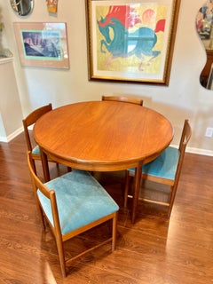 A MCM round teak dining table by G plan, with one 18" pop up leaf