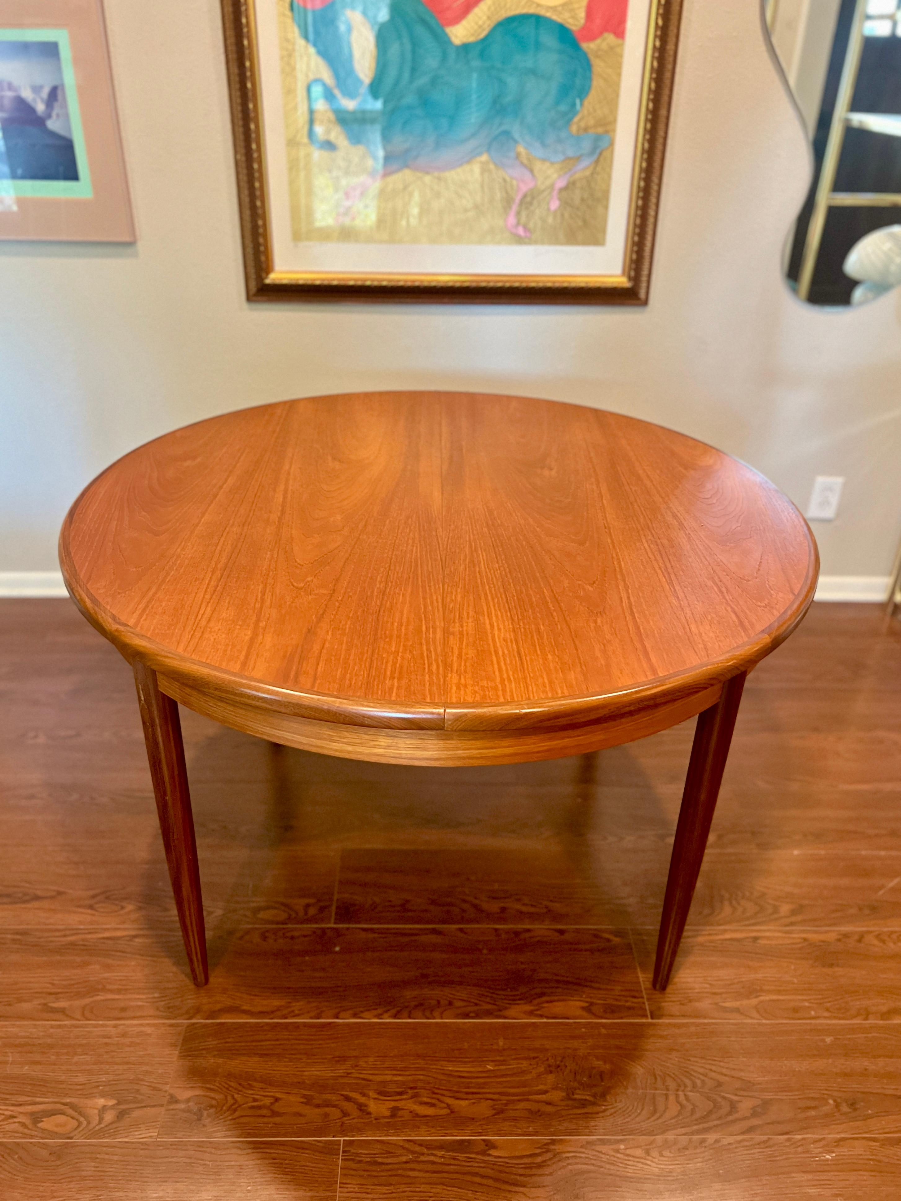 A MCM round teak dining table by G plan, with one 18