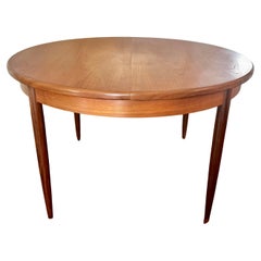 Vintage A MCM round teak dining table by G plan, with one 18" pop up leaf 