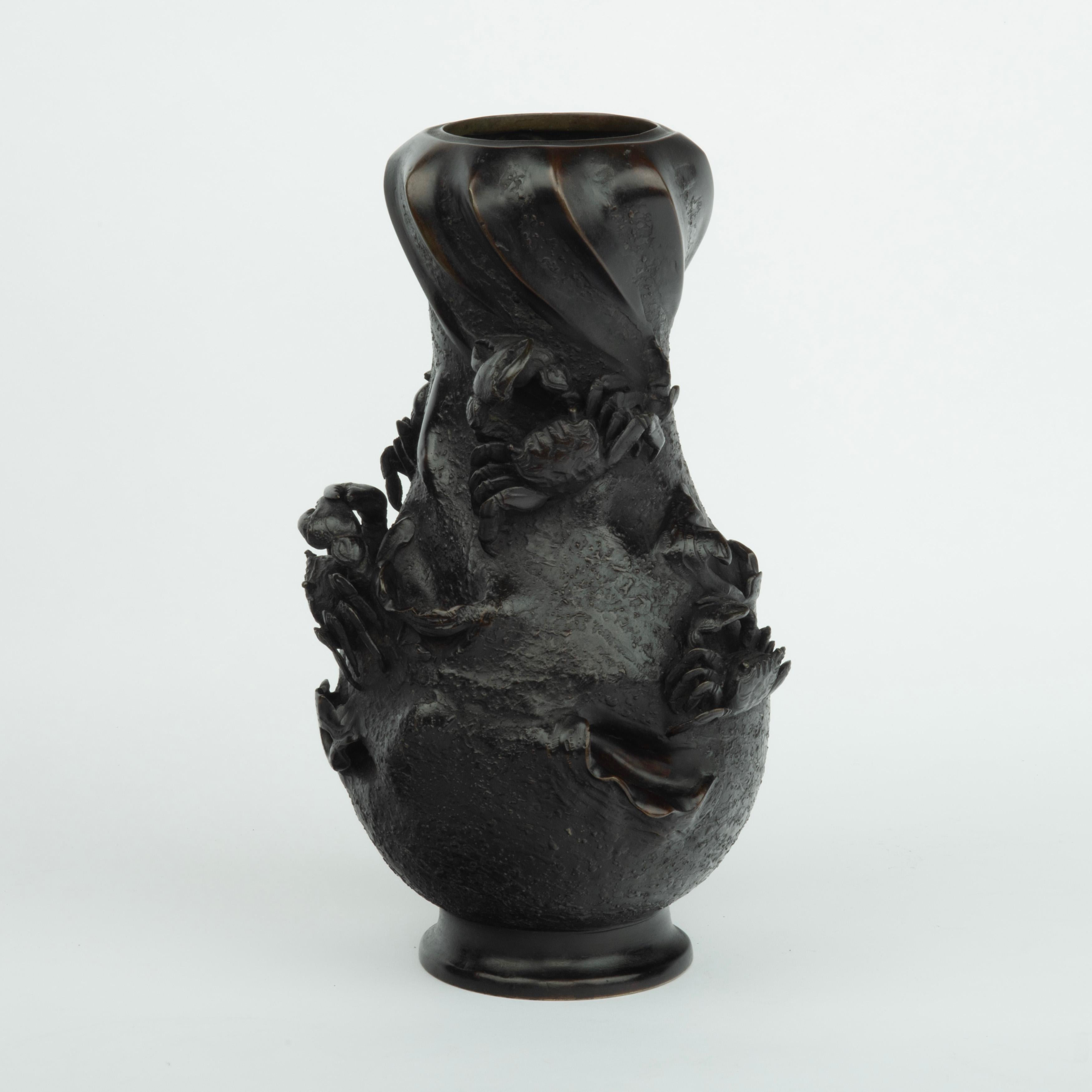 Vase en bronze Meiji par Nobuhira, de forme balustre avec un col torsadé en spirale, le corps décoré de quatre crabes en haut-relief et de plusieurs coquilles de palourdes ouvertes partiellement exposées sur un fond texturé.  Estampillé 