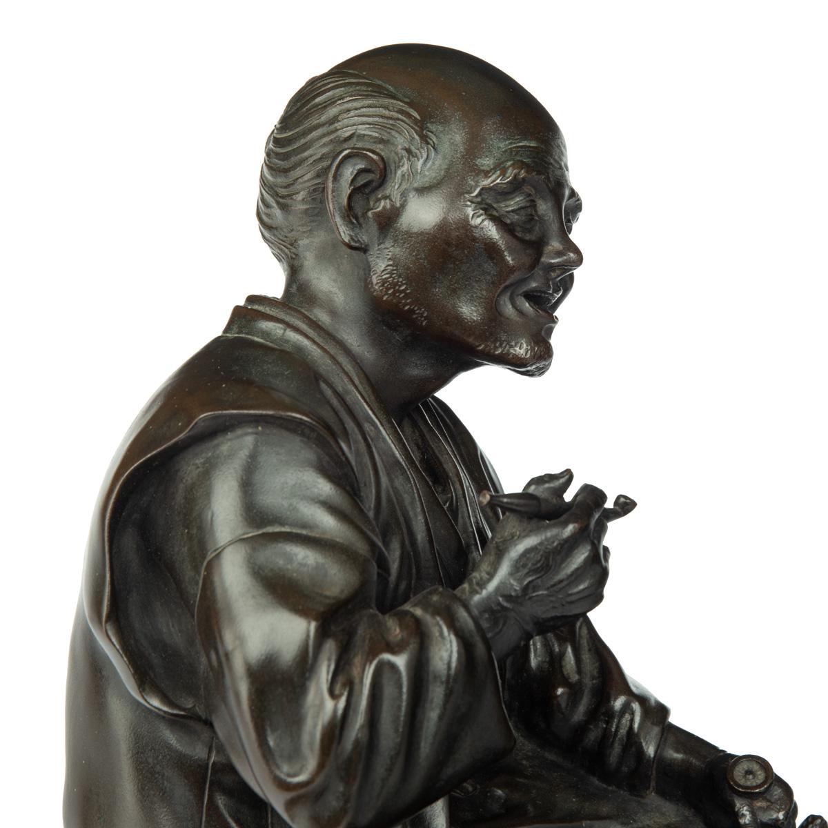 Bronze A Meiji period bronze of a seated man smoking For Sale