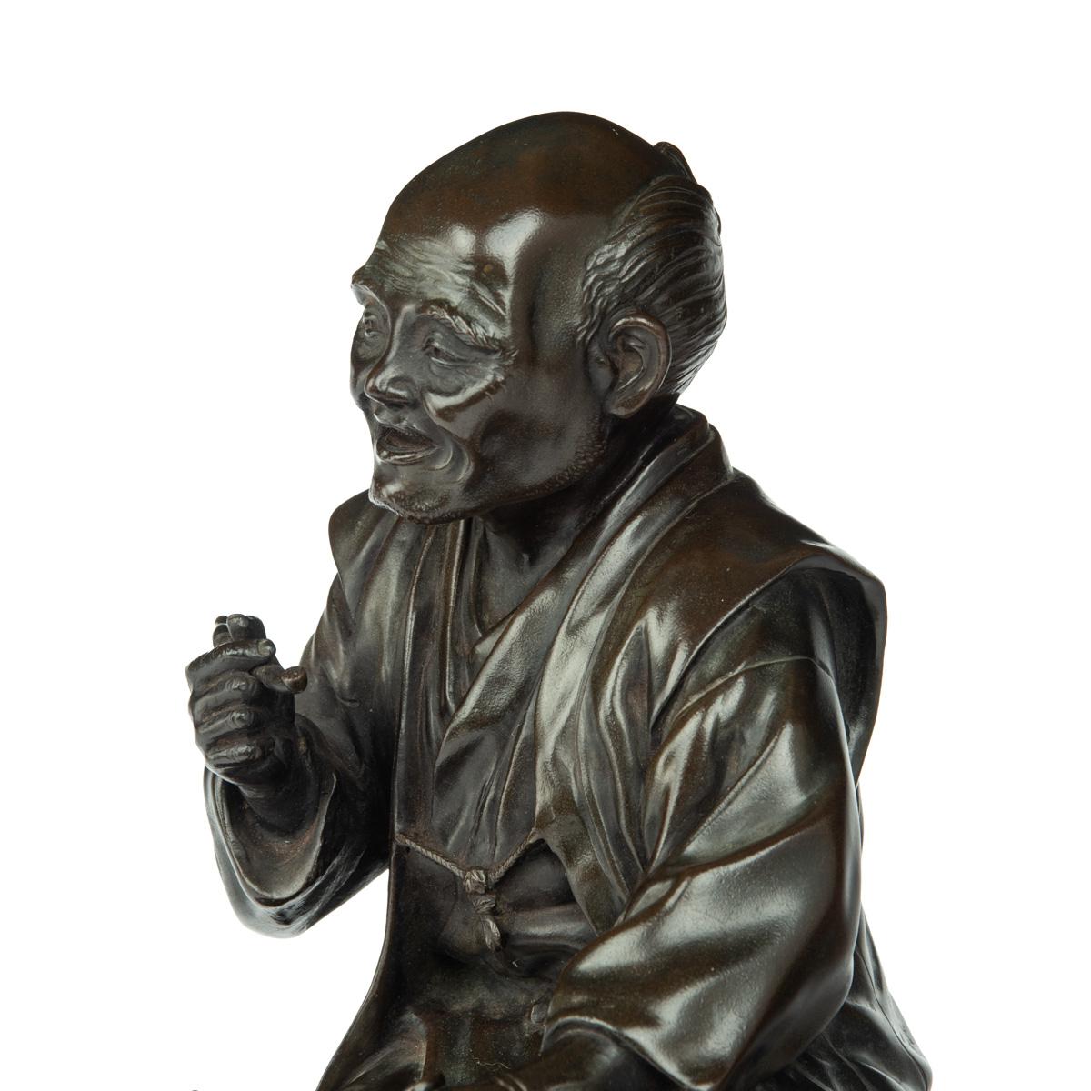 A Meiji period bronze of a seated man smoking For Sale 1