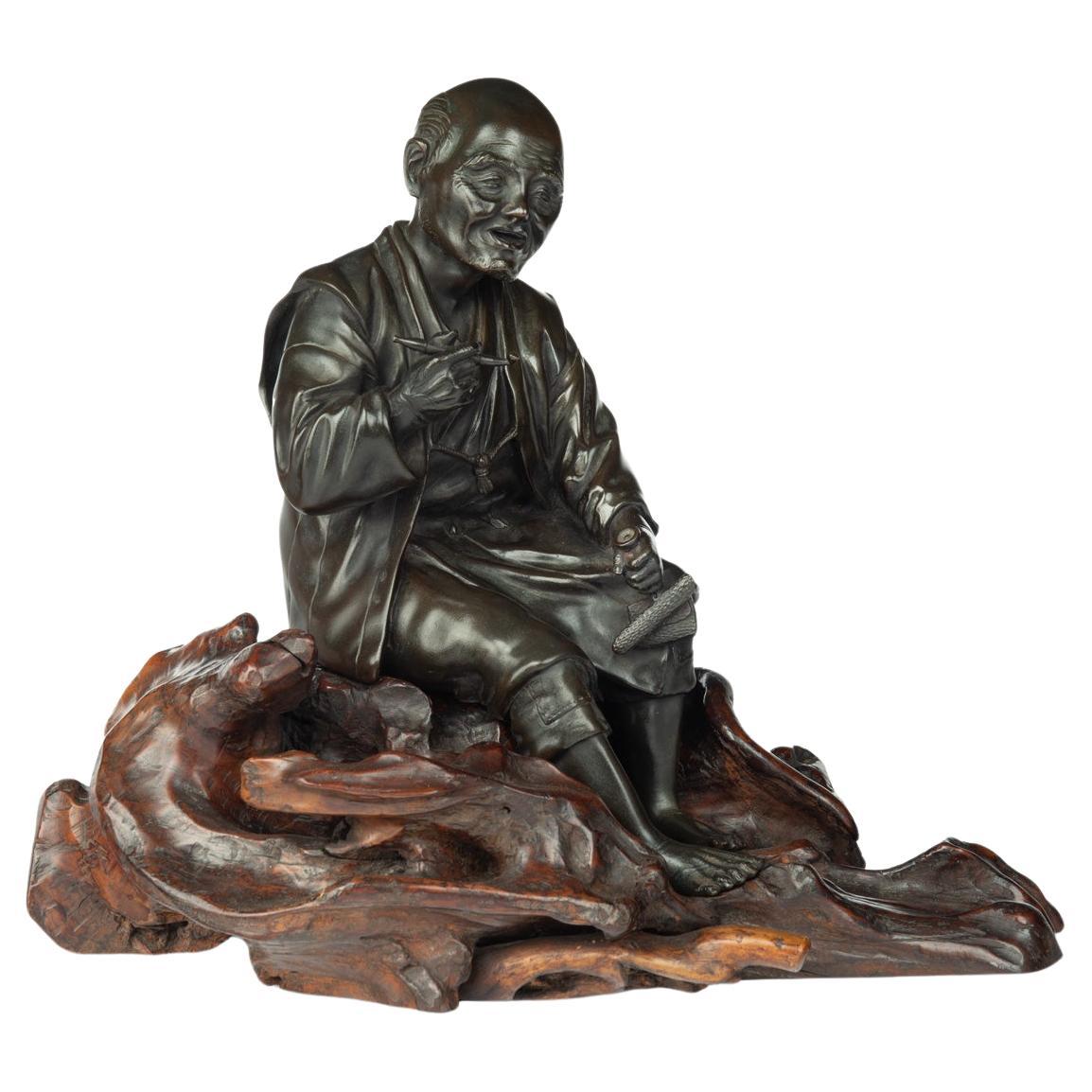 Bronze aus der Meiji-Periode eines sitzenden Mannes, der raucht im Angebot