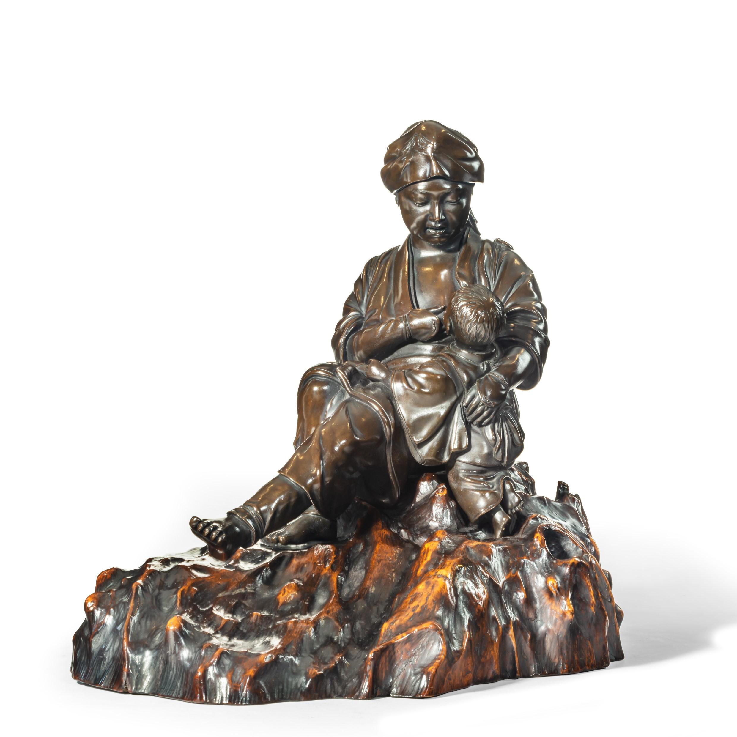 A Meiji period bronze sculpture of a mother and son by Atsuyoshi, she is shown seated on a gnarled rootwood base, with her arm round a crying boy standing by her knee and offering her breast, wearing a short robe, trousers and a cloth incised with