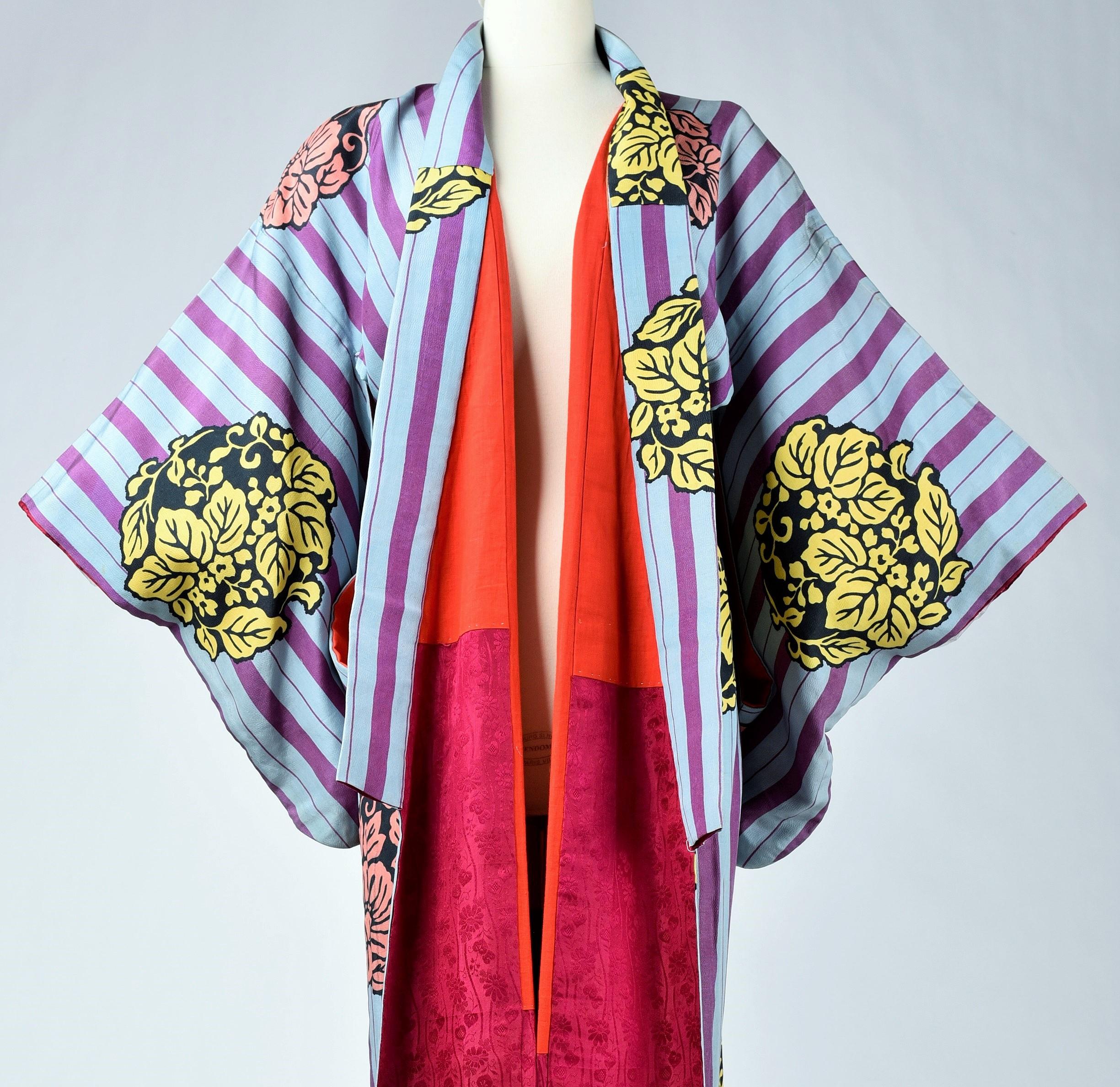 Circa 1930-1940

Japan

Kimono for evening or indoor use with long sleeves called Furisode and dating from the Art Deco period in Japan. Meisen printed silk crepe with large blue and purple stripes dotted with large yellow, salmon and black floral