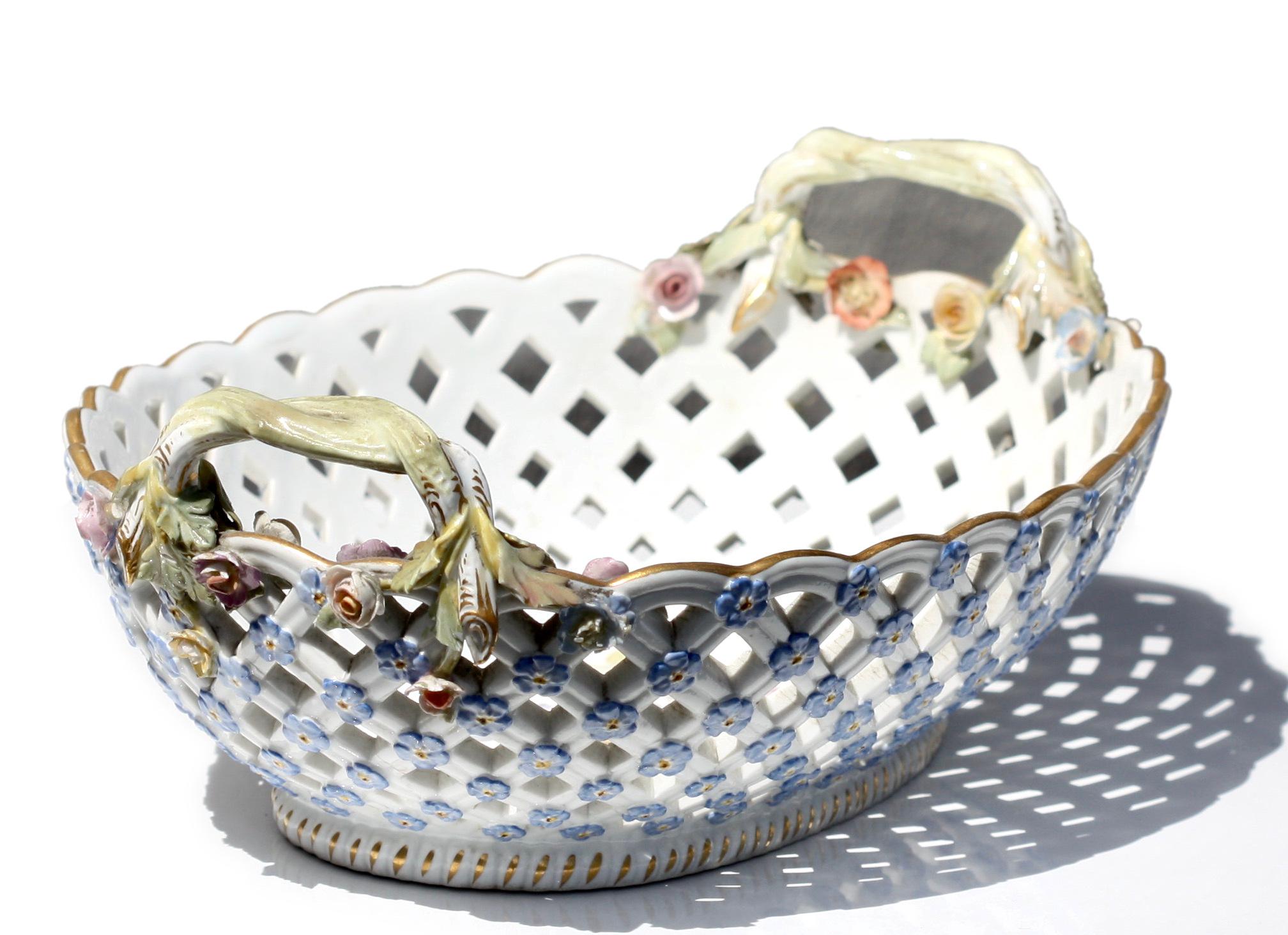 
A Meissen Porcelain Reticulated Two-Handled Basket, 
late 19th century
Of oval outline, pierced to resemble a basketweave, applied with flowerheads and flanked by entwined branch handles, painted to center with a floral spray, underglaze blue
