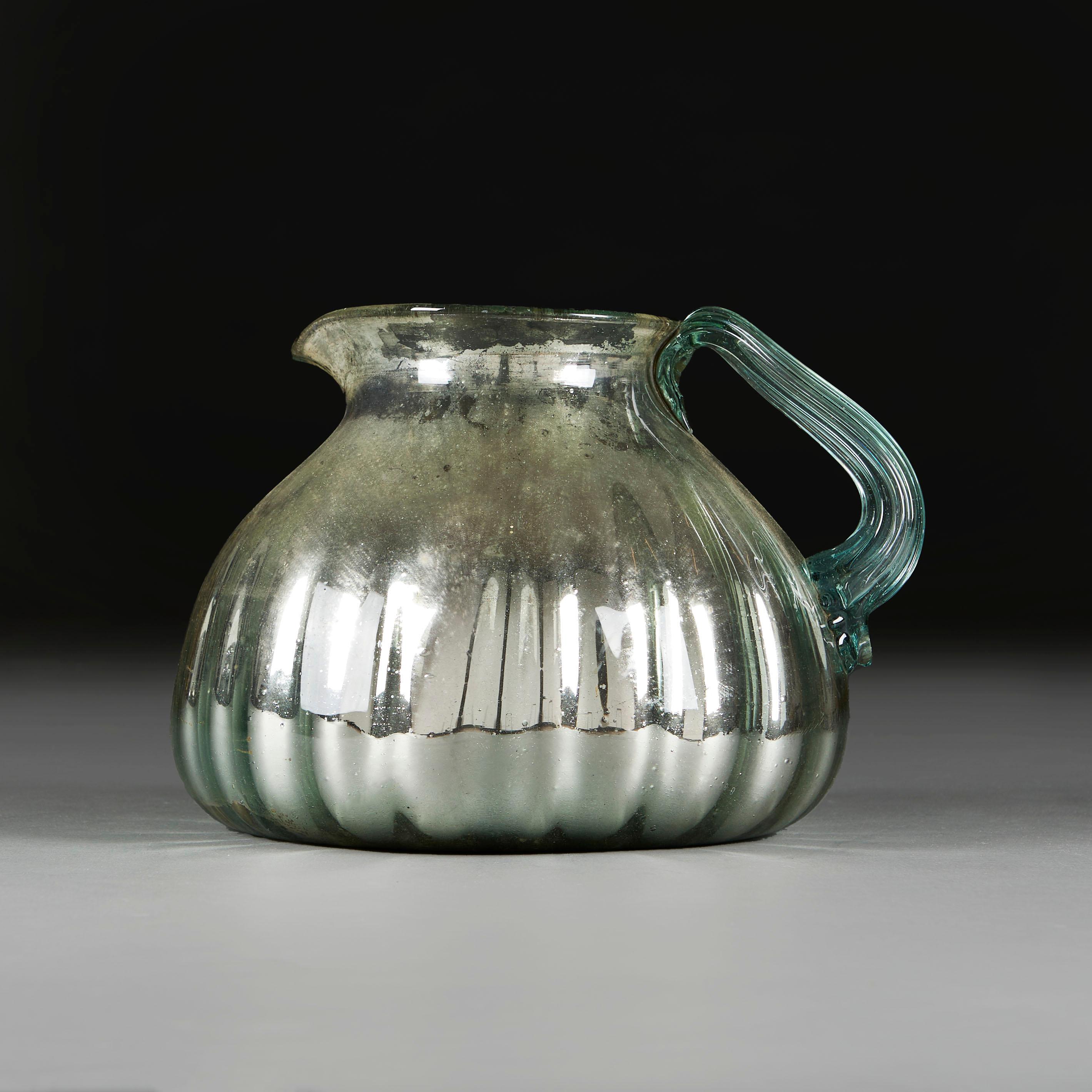 Francia, circa 1940

Vaso in vetro al mercurio francese dell'inizio del XX secolo, con corpo a forma di gadroon e bordo svasato, con manico ad anello in vetro trasparente scanalato su un lato. 

Altezza    23.00cm

Larghezza      31.00cm

Profondità