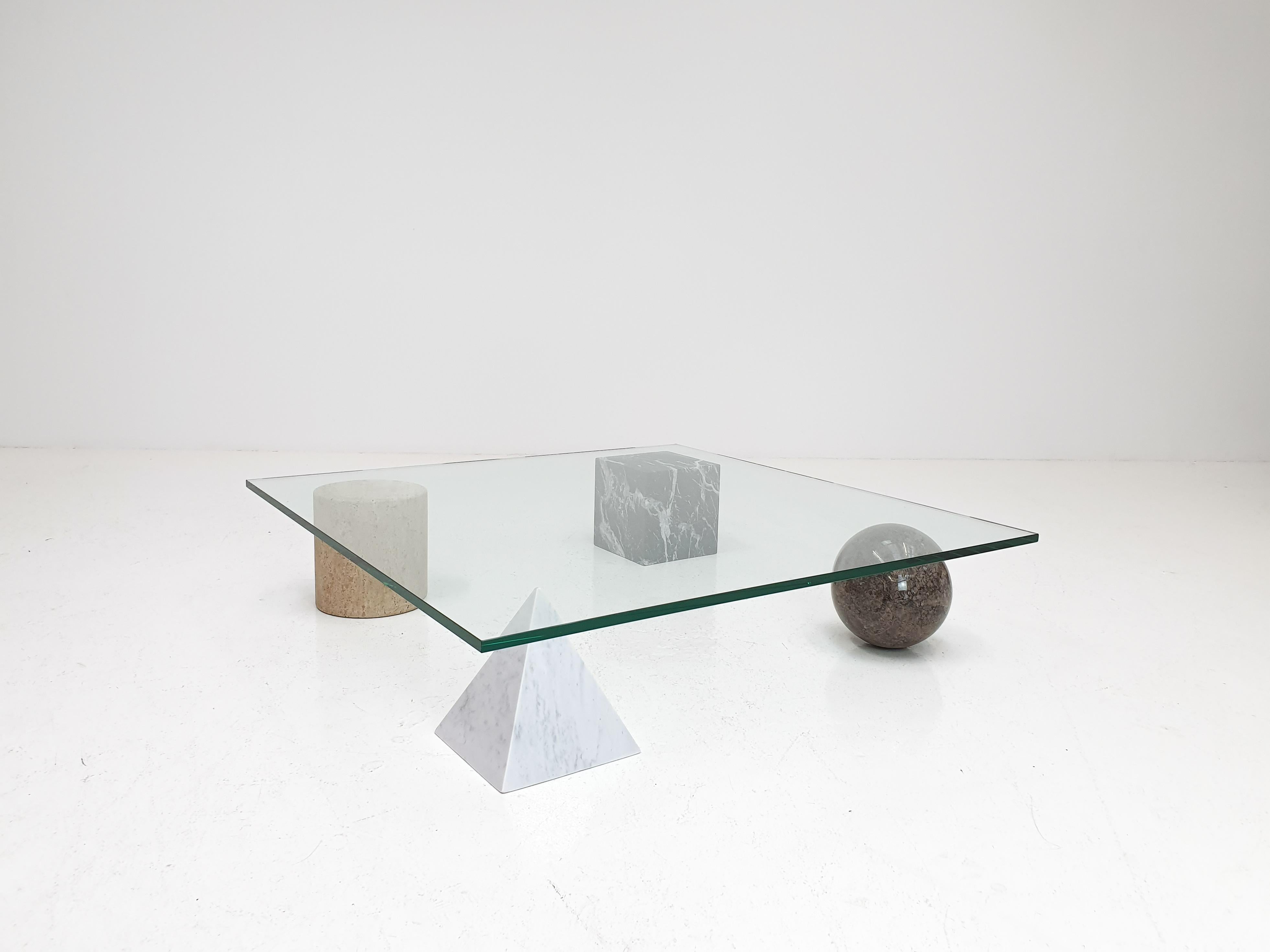 A ‘Metafora’ coffee table by Massimo and Lella Vignelli for Casigliani, Italy. 

Constructed of four geometric marble shapes which form the base including a solid Carrara marble pyramid, travertine cylinder, black marble block and granite sphere
