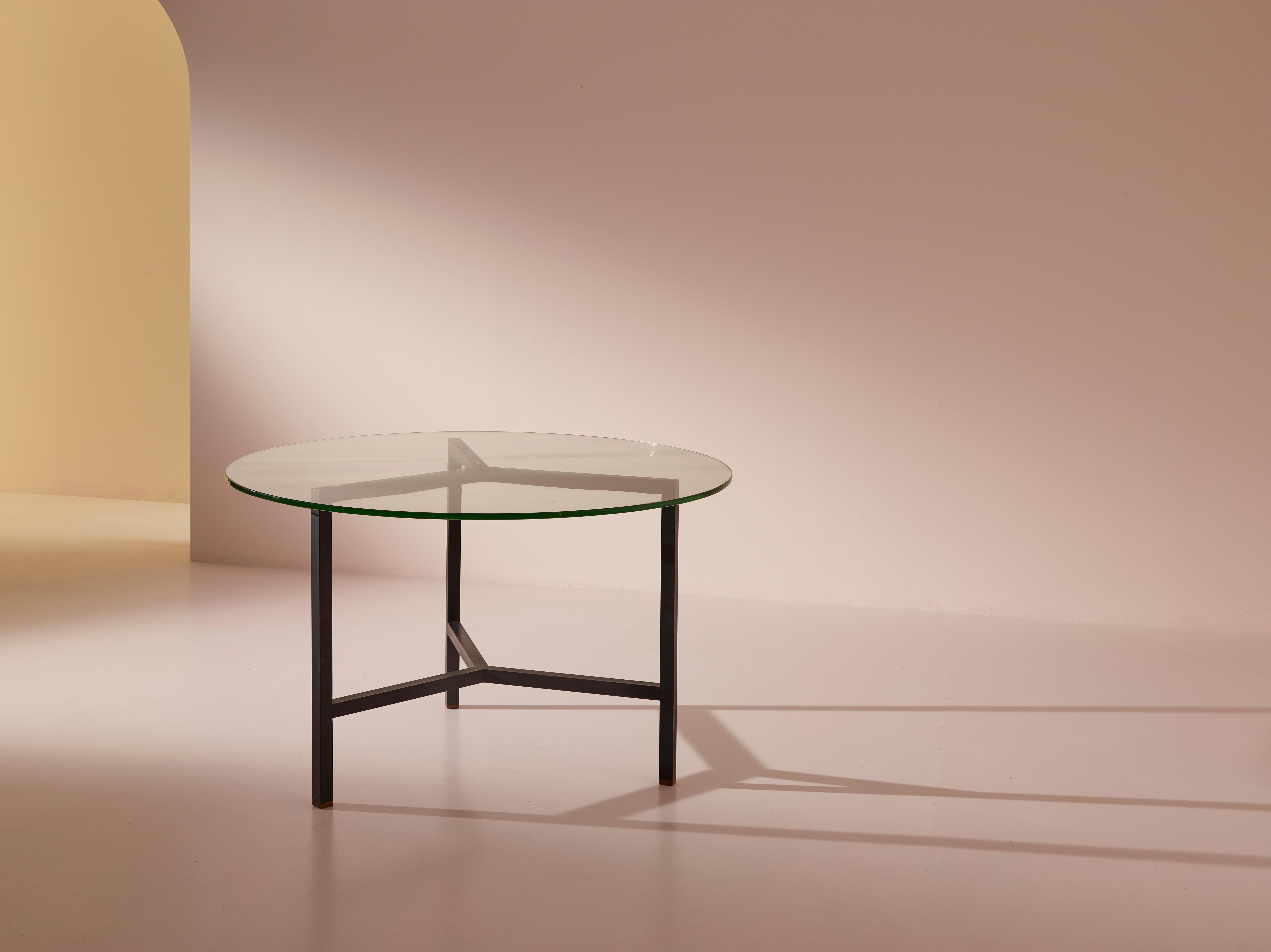 A round metal and glass dining table of Italian manufacture from the 1950s. 

In its simplicity, this small table expresses the potential of two materials that may seem opposites but can nonetheless interact with great aesthetic appeal. The hardness