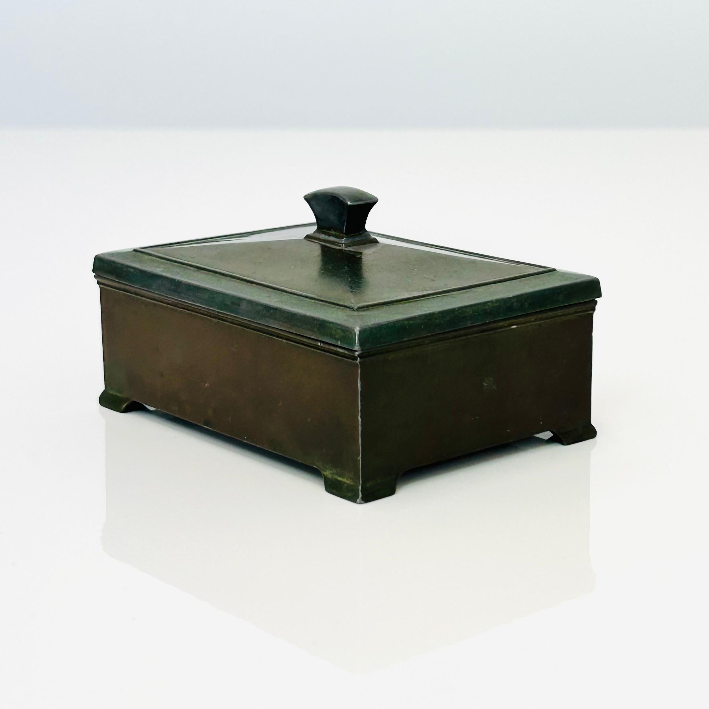 A lidded metal casket / jewellery box designed by and produced by Just Andersen in the 1930s. It is made of 'Diskometal' - an alloy invented by Just Andersen - with an inside box in wood. It is in good vintage condition with small marks at the
