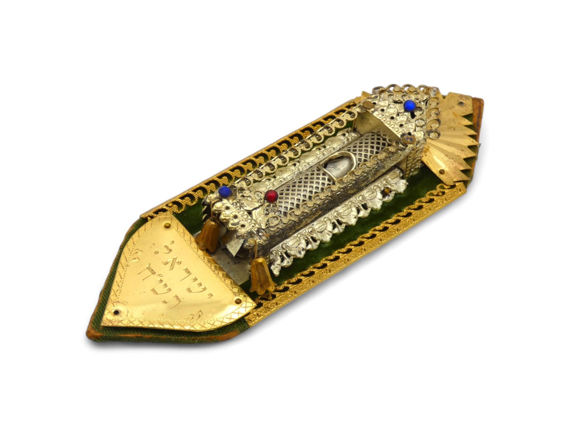 An Art and crafts Mezuzah Case made in Israel in 1948.

Early Israeli Mezuzah case on a shaped piece of wood covered in green velvet with a scroll encased in an ornate pierced silvered body, contained within a stylized Chuppah canopy or an ark for