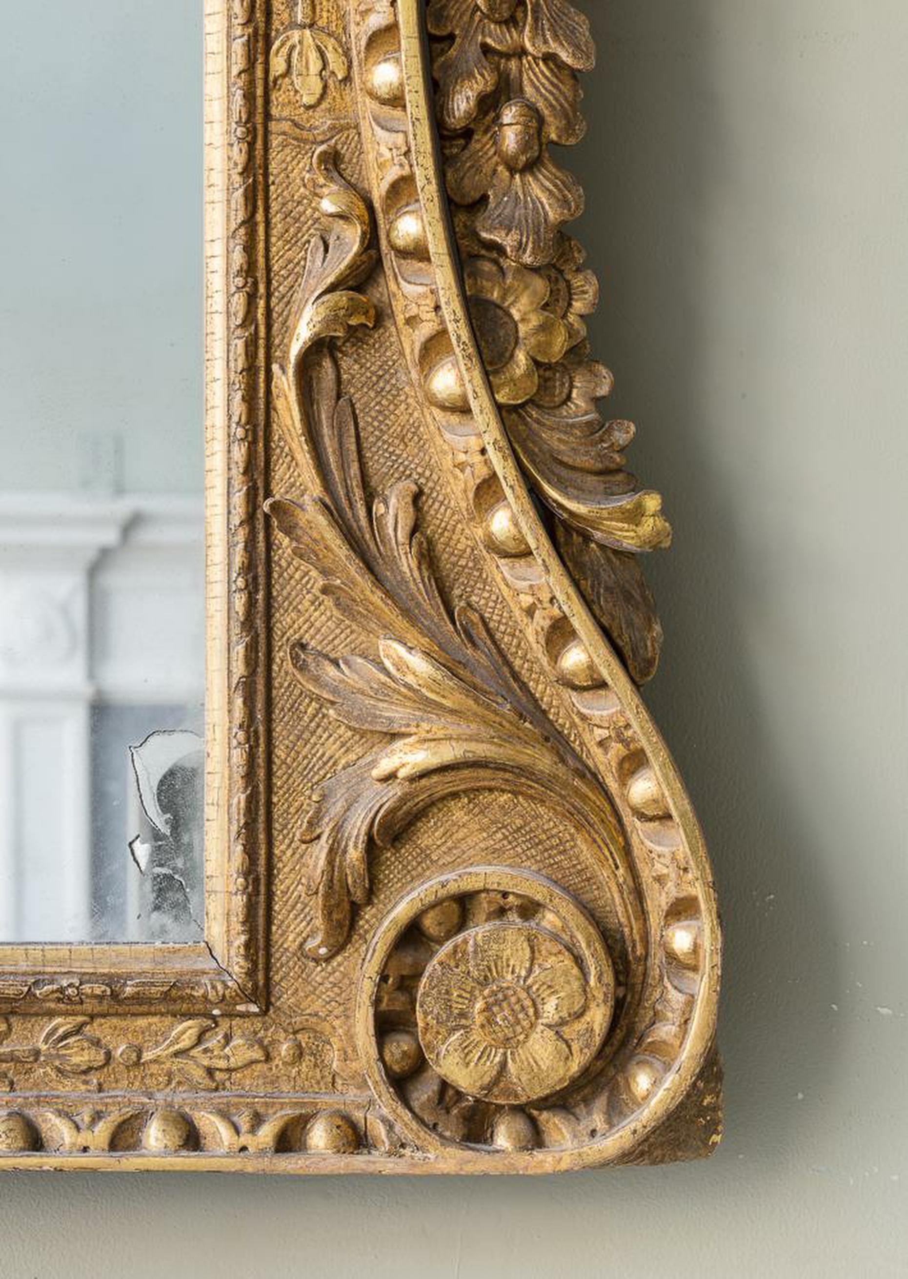 Giltwood overmantle mirror
A mid 18th century carved giltwood overmantle mirror, with swan neck broken pediment centred by a scrolling foliate cartouche, above shell and acanthus decorated frieze, with overall egg and dart carved reentrant frame,