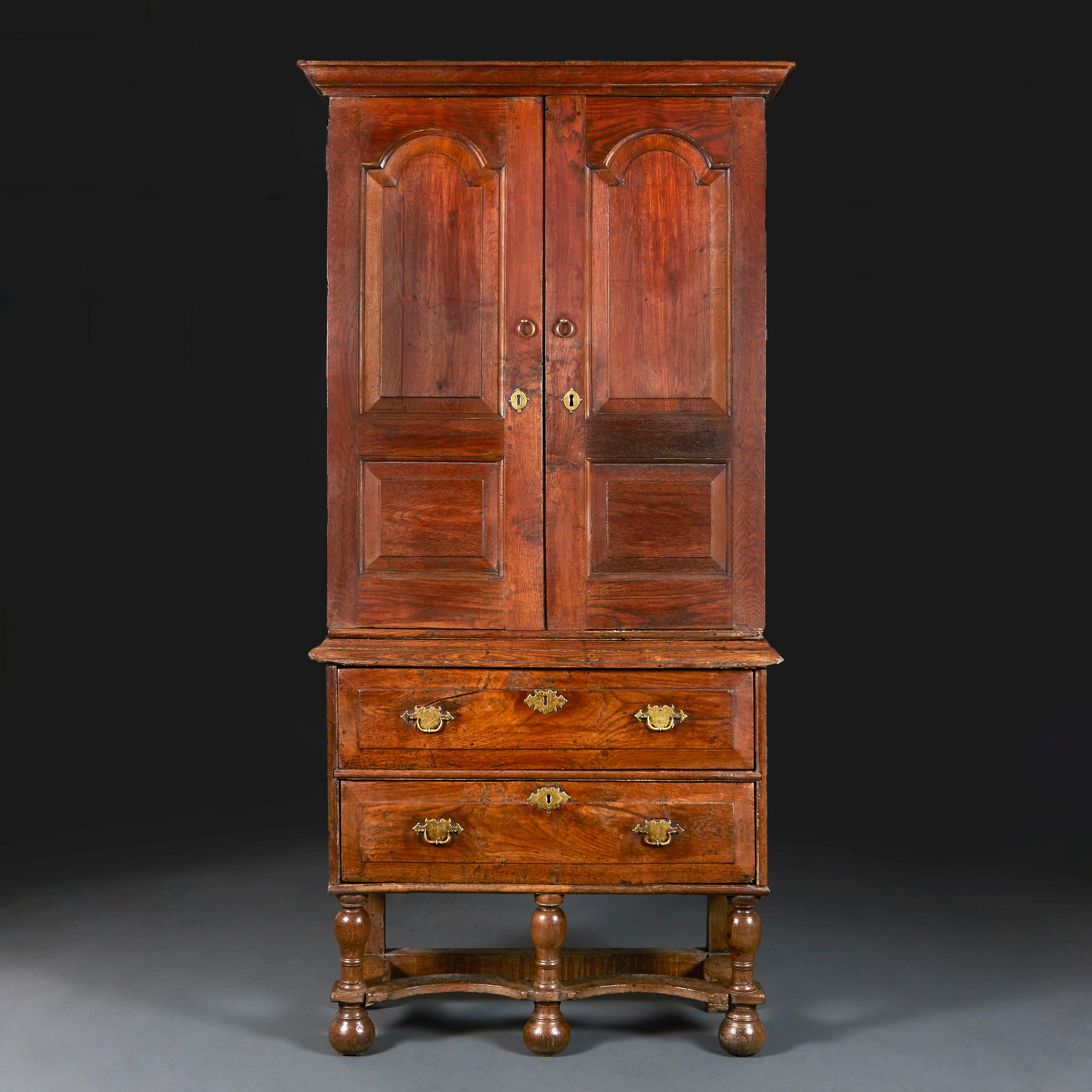 England, circa 1750

A fine mid-eighteenth century elm cabinet with two panelled doors above a secret draw, the interior fitted with shelves and pigeonholes with two draws, all supported on a stand with cross-stretcher.

Height 197.00cm
Width