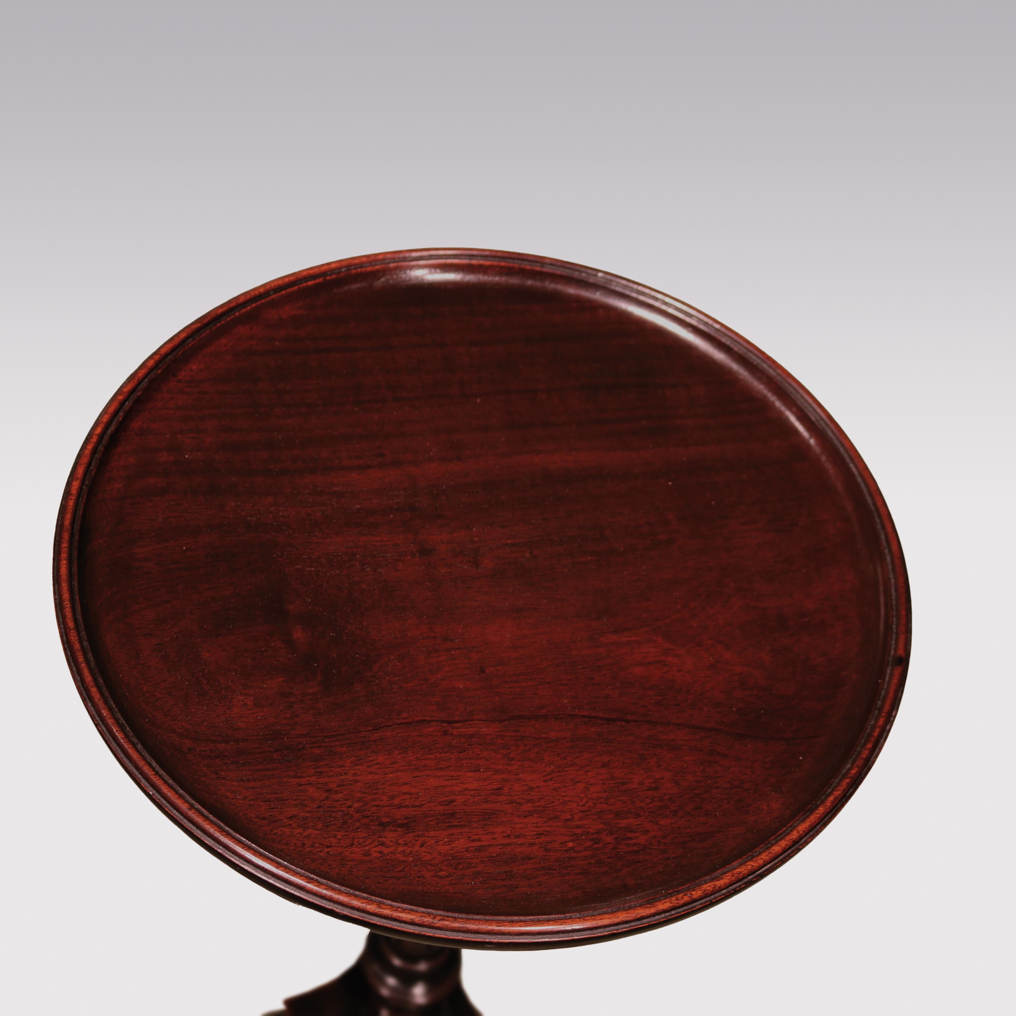 A mid-18th century mahogany tripod table or kettle stand having moulded edge circular top above ring turned baluster stem raised on tripod leg base.