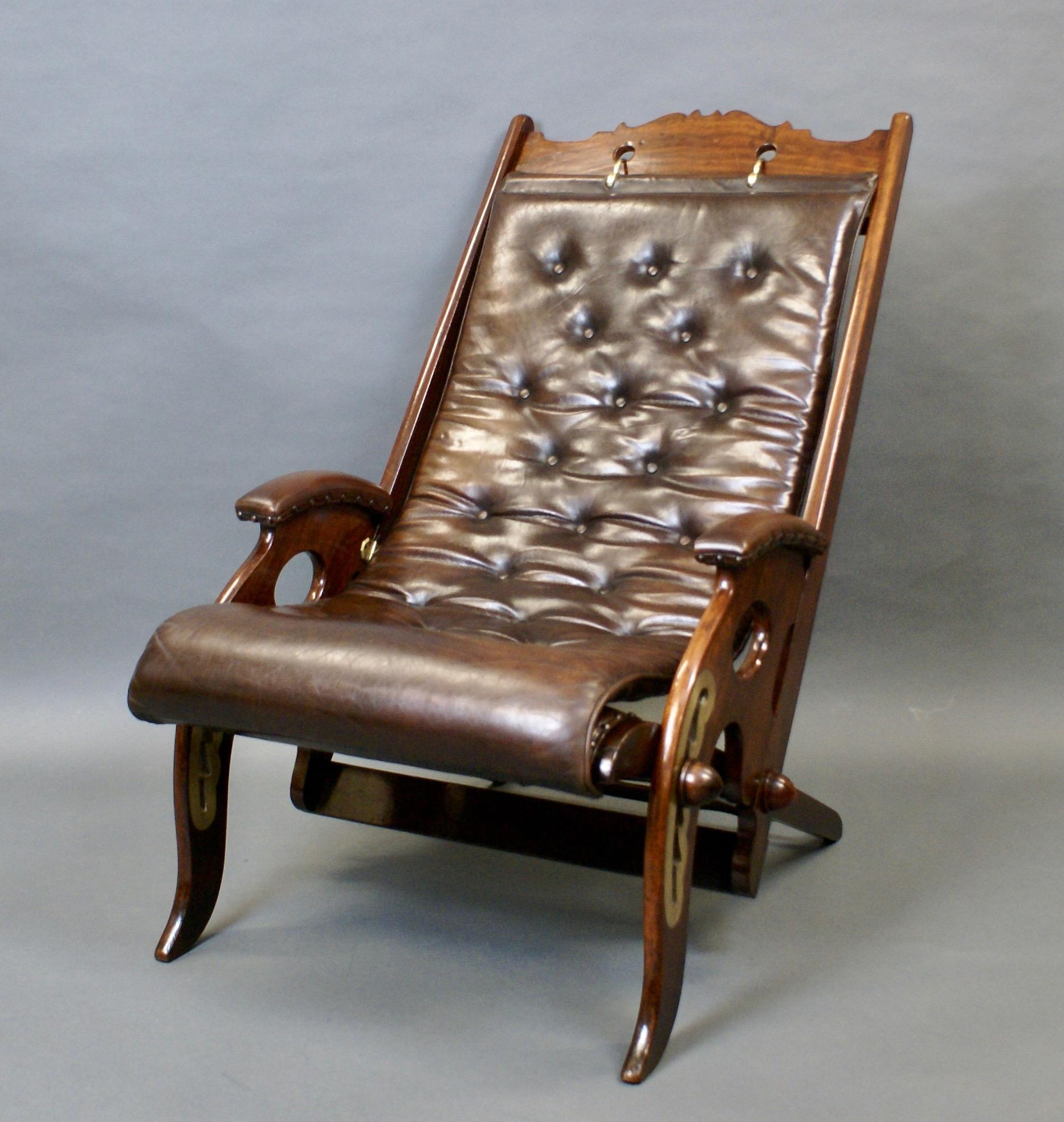 A mid 19th century adjustable deck chair. In mahogany with brass mounted ratchets to alter the height and angle of the chair and with buttoned leather upholstered seat and arm pads. In very good fully working order and condition. A great example of