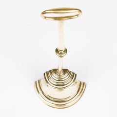 A mid 19th century brass bell shaped door stop