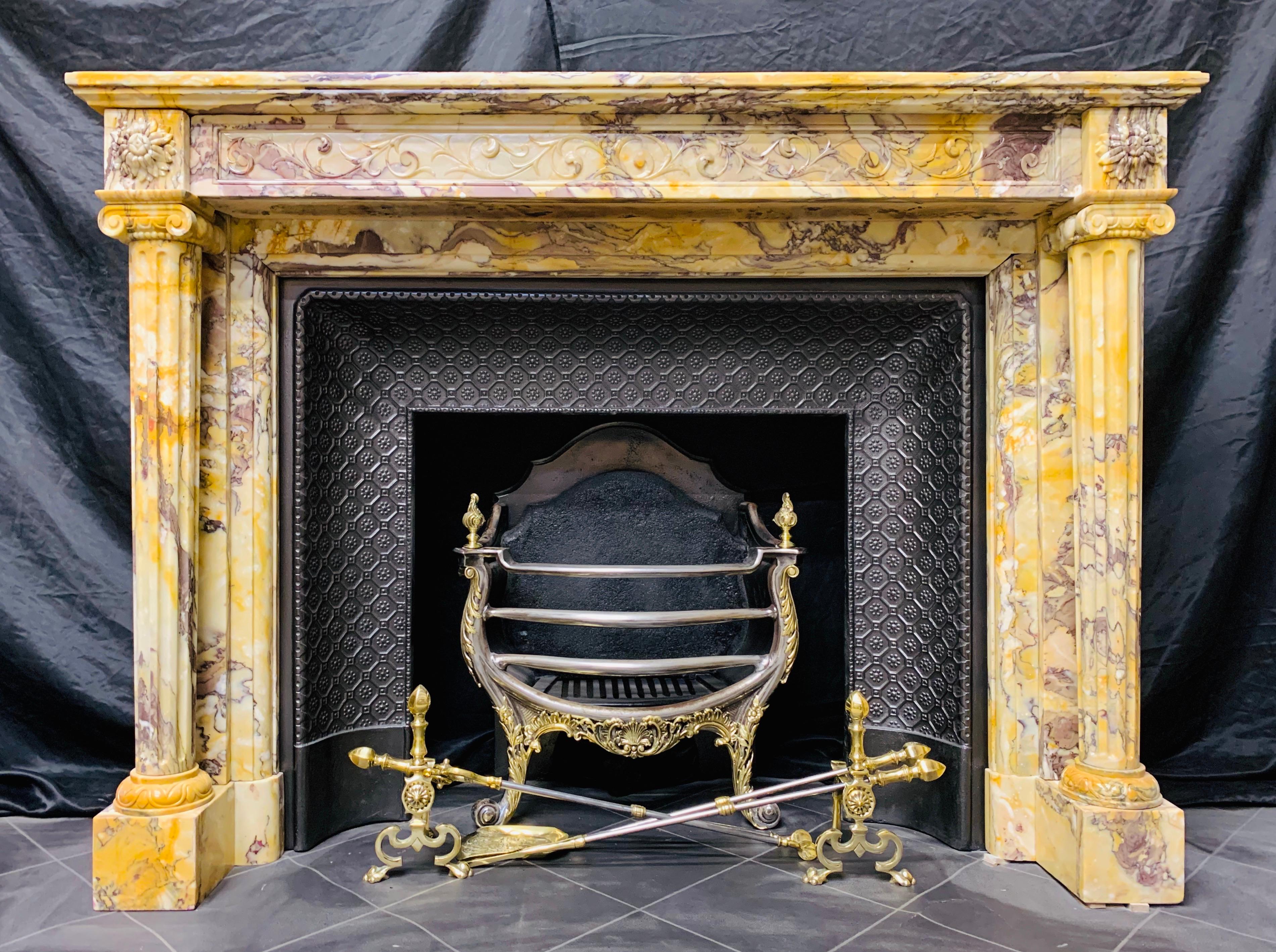A very fine mid-19th Century French neoclassical fireplace surround in golden vibrant Convent Giallo di Siena marble. A deep rectangular shelf with an edged moulding gracefully rests on an elegant framed high relief carved frieze showing full length