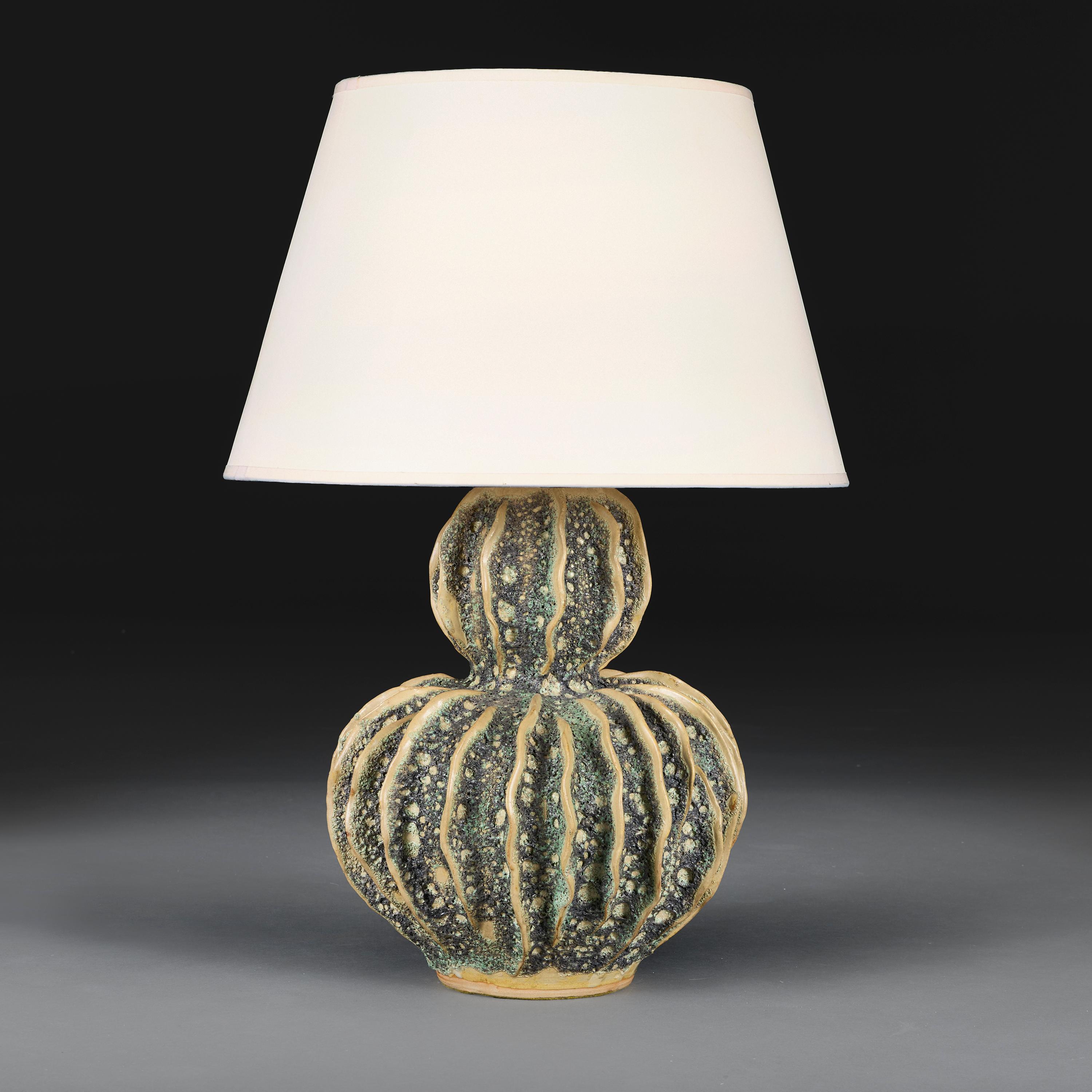 French, circa 1960

A mid-20th century double gourd pottery cactus lamp decorated with a copper volcanic glaze throughout. 

Height of vase    40.00cm
Width of body   29.00cm

Please note:

Lampshade not included. Lamp photographed with a 18”