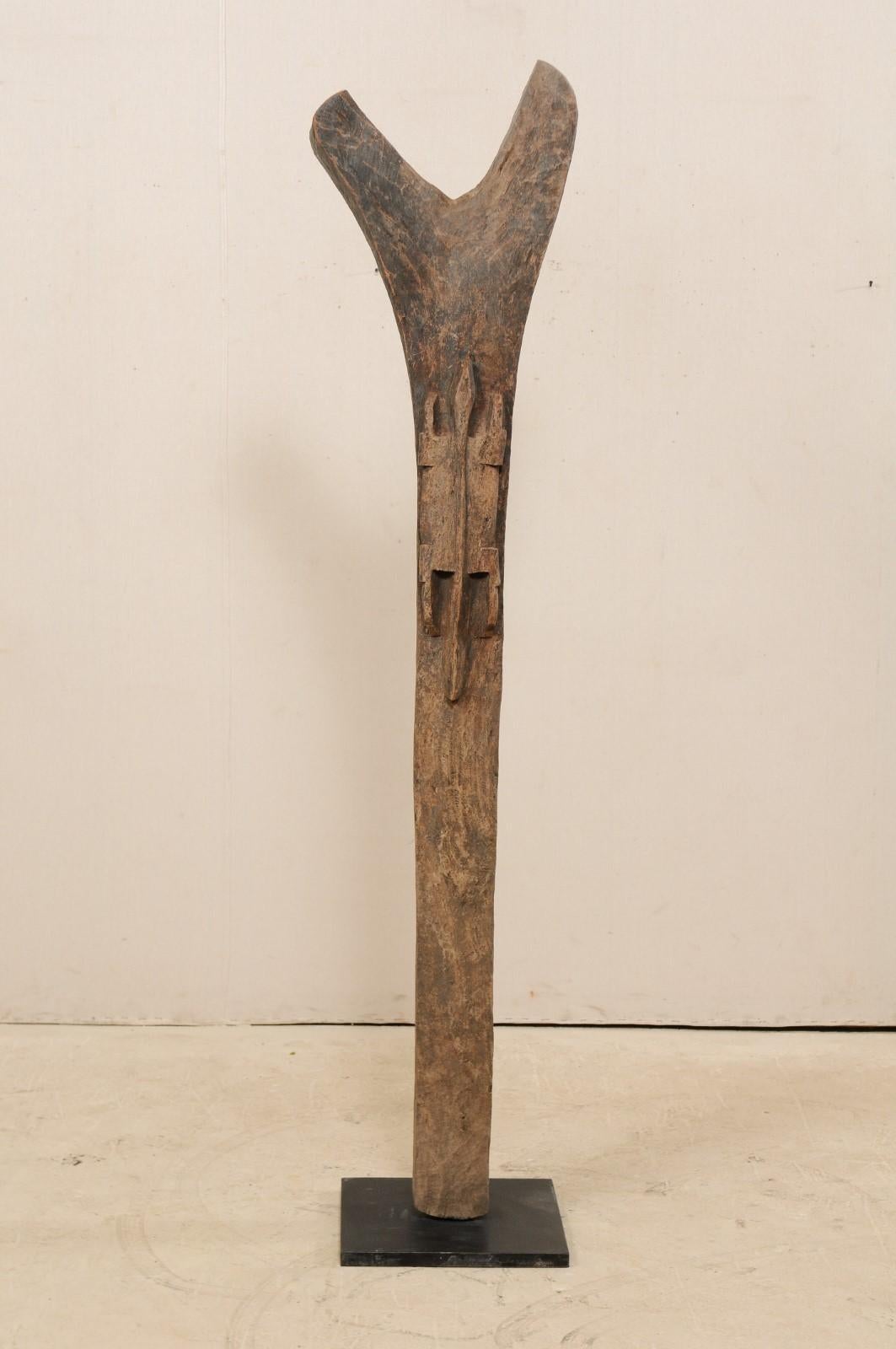 An early to mid-20th century Toguna support post from the Dogon Tribe of Mali, on custom metal Stand. This West African hand carved wooden bean was originally used for supporting the 