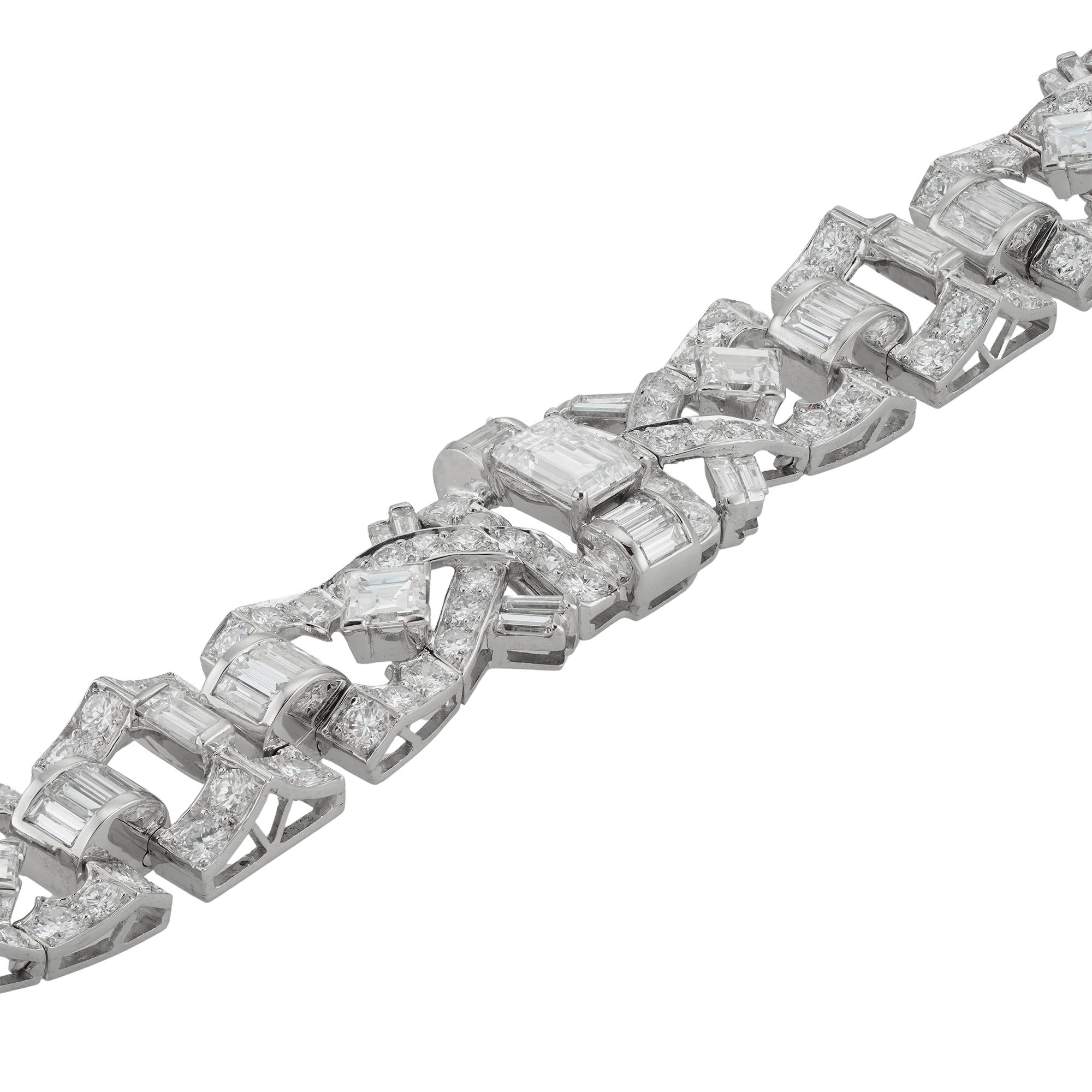 Bracelet serti de diamants datant du milieu du XXe siècle, composé de six panneaux ajourés à motifs géométriques, sertis au centre d'un diamant taille émeraude d'un poids estimé à 1,1 carat, de deux diamants taille émeraude plus petits d'un poids