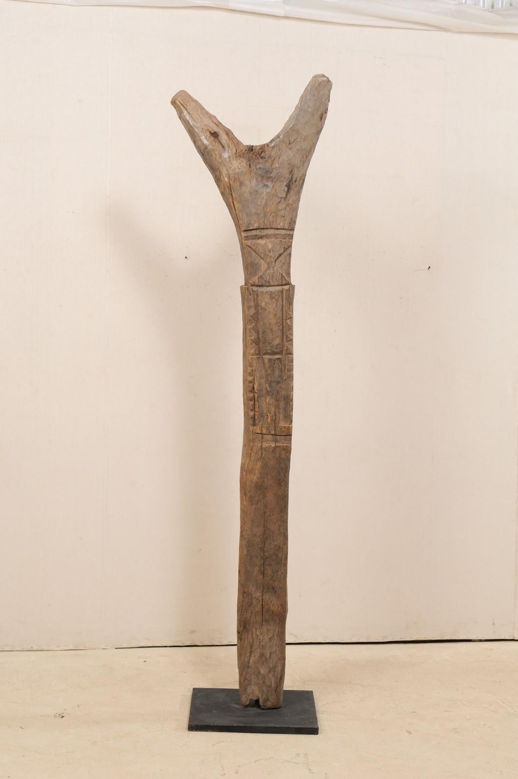An early to mid-20th century Toguna support post from the Dogon Tribe of Mali, on custom metal stand. This West African hand carved wooden bean was originally used for supporting the 