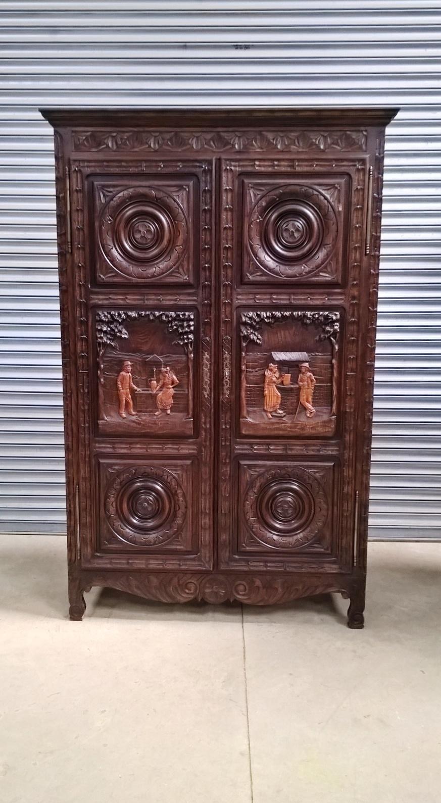 A French oak armoire originating from the region of Brittany.

The top with a stepped pediment and a carved frieze of flowers within triangular frames below.

The pair of doors each with three panels, two being of circular design and the central