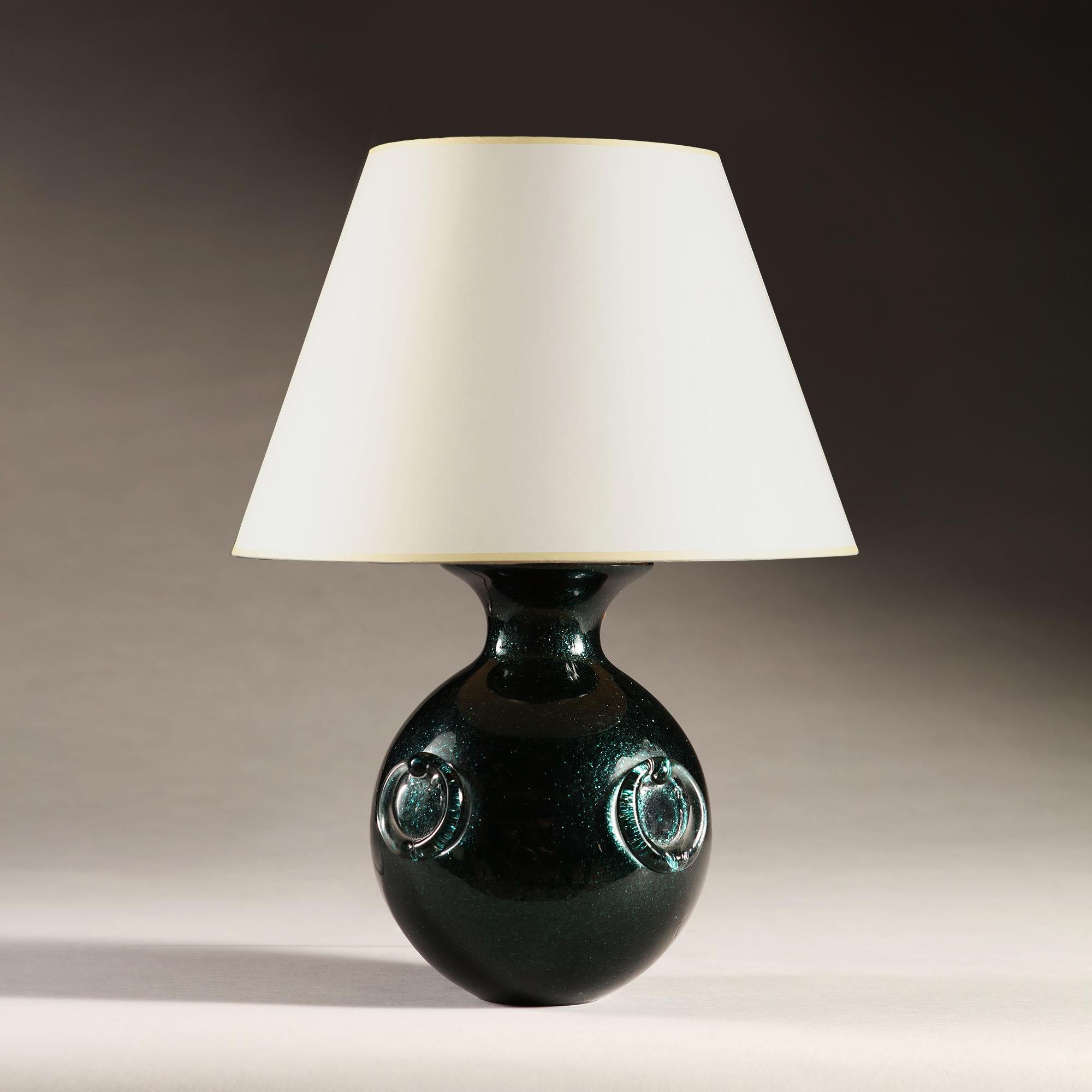 A small 20th century Murano glass ball lamp of iridescent dark green colour, with four clear glass handles to each side. 

Please note: lampshade not included.

Currently wired for the UK.