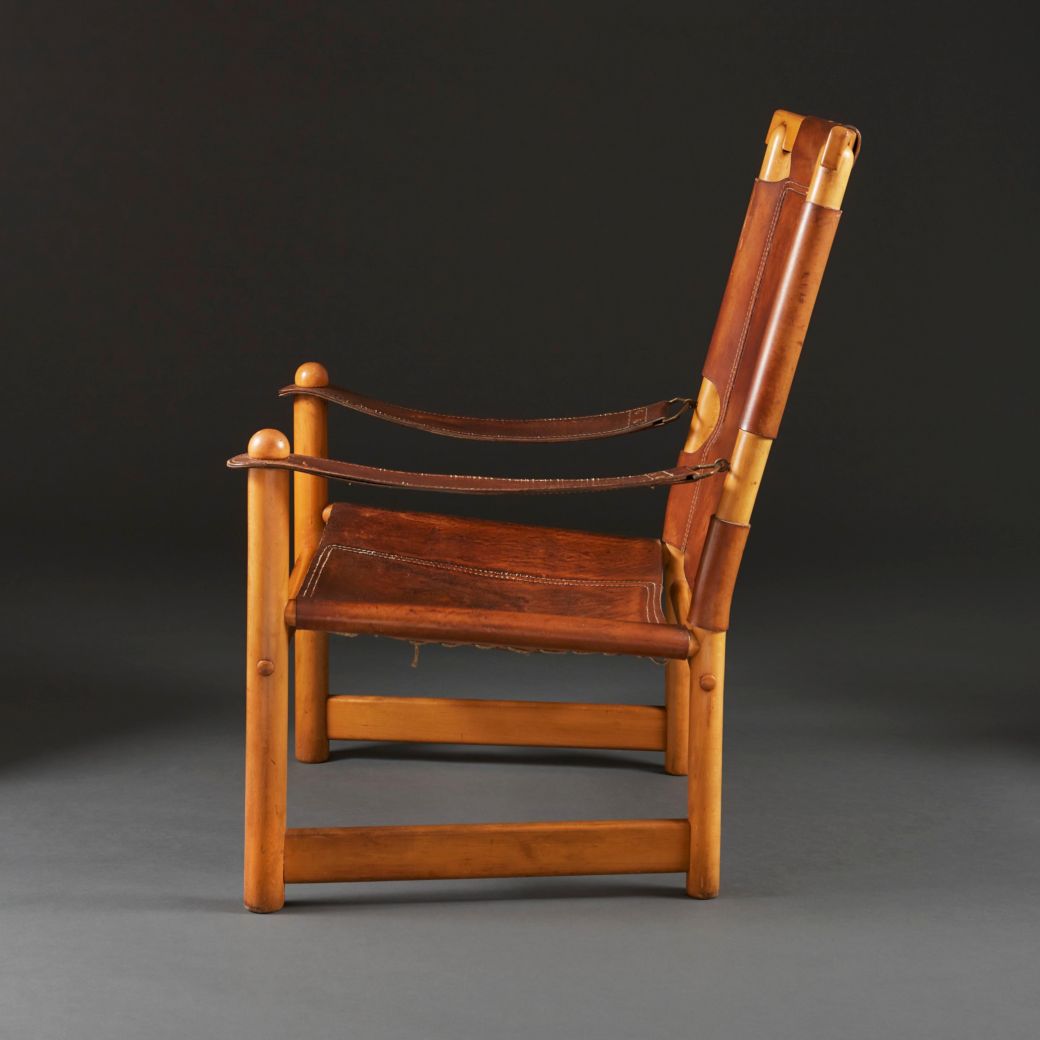 A mid-20th century Italian leather and pine armchair, the original leather showing wonderful patination, the leather stitched around the frame on the back and the seat, the arms made from leather straps with unusual metal buckle attachment to the