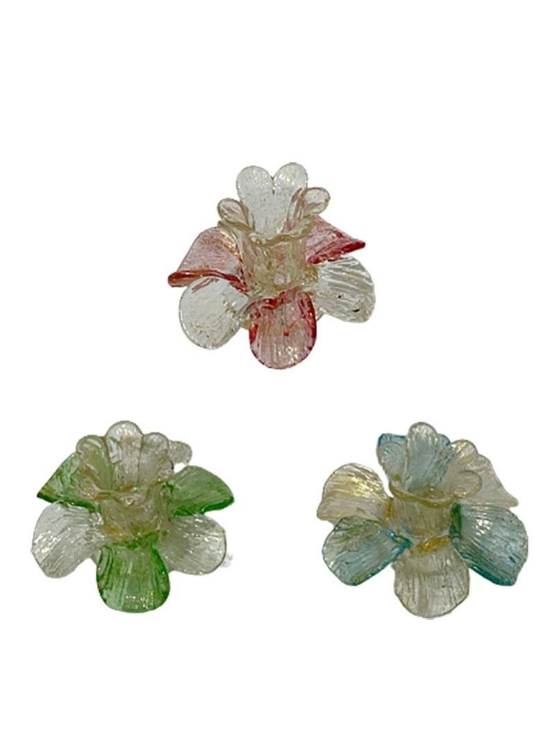 A mid-20th century Italian Murano gold flake candleholders in flower shape. 

A flower chalice, containing the candle with 6 leaves in clear and green, pink or blue glass colors on a round base. 
The candleholders have a ribbed motif with gold