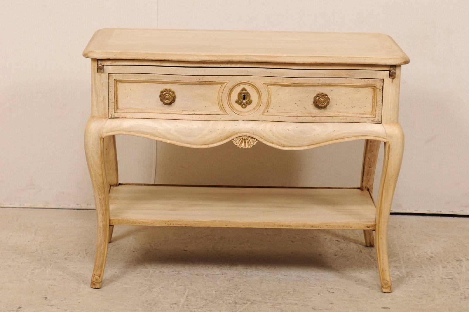 An American single-drawer chest with lower shelf from the mid-20th century. This American mid-century chest or table features a beautiful bleached wood finish, scalloped skirt on all four sides, and is raised upon four elegant cabriole legs. There