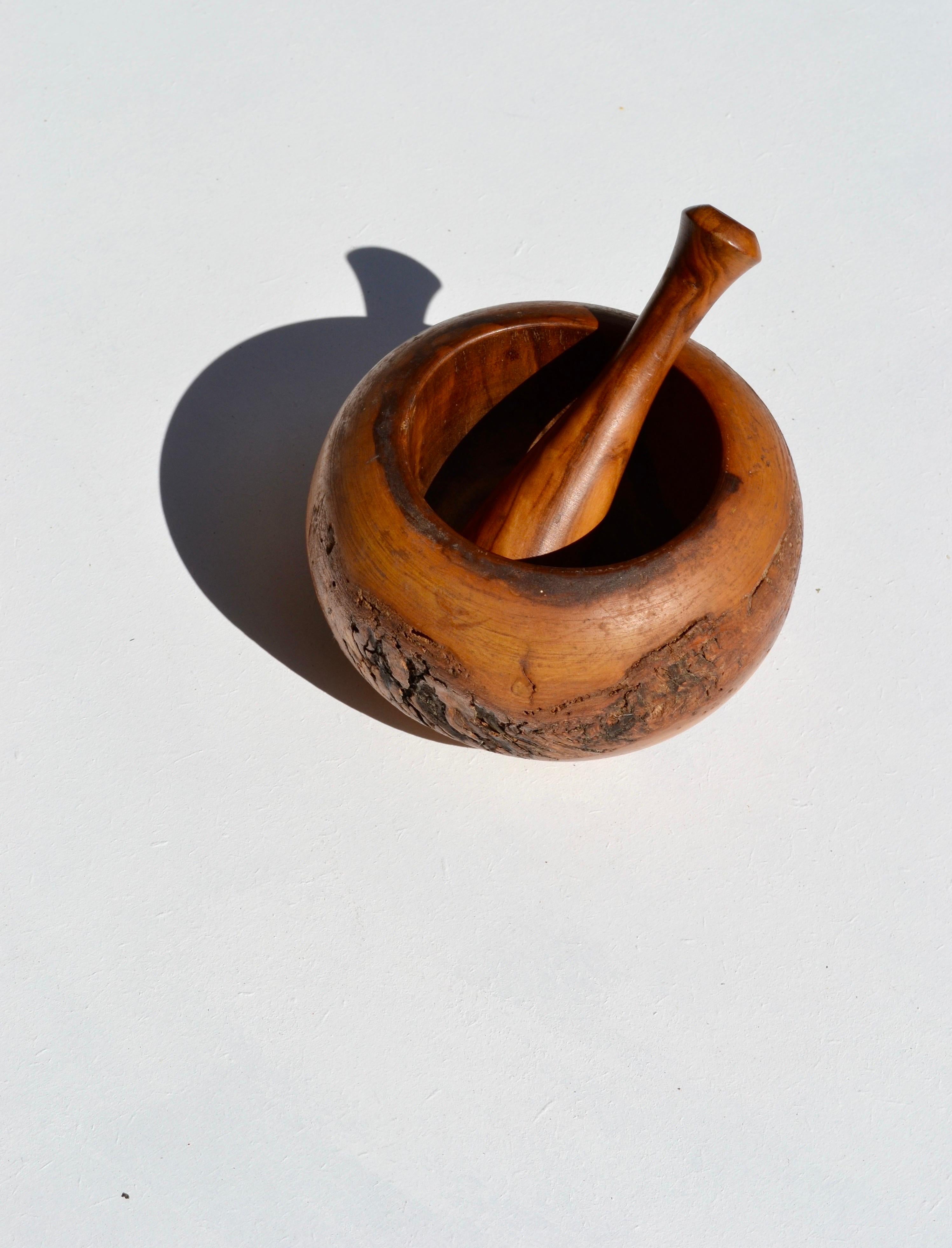 Realizzato a mano in Francia con legno d'ulivo dalla ricca venatura, questo mortaio e pestello della metà del XX secolo incarna la bellezza e l'autenticità della tradizione artigianale. Le sue calde tonalità naturali e la sua forma organica lo
