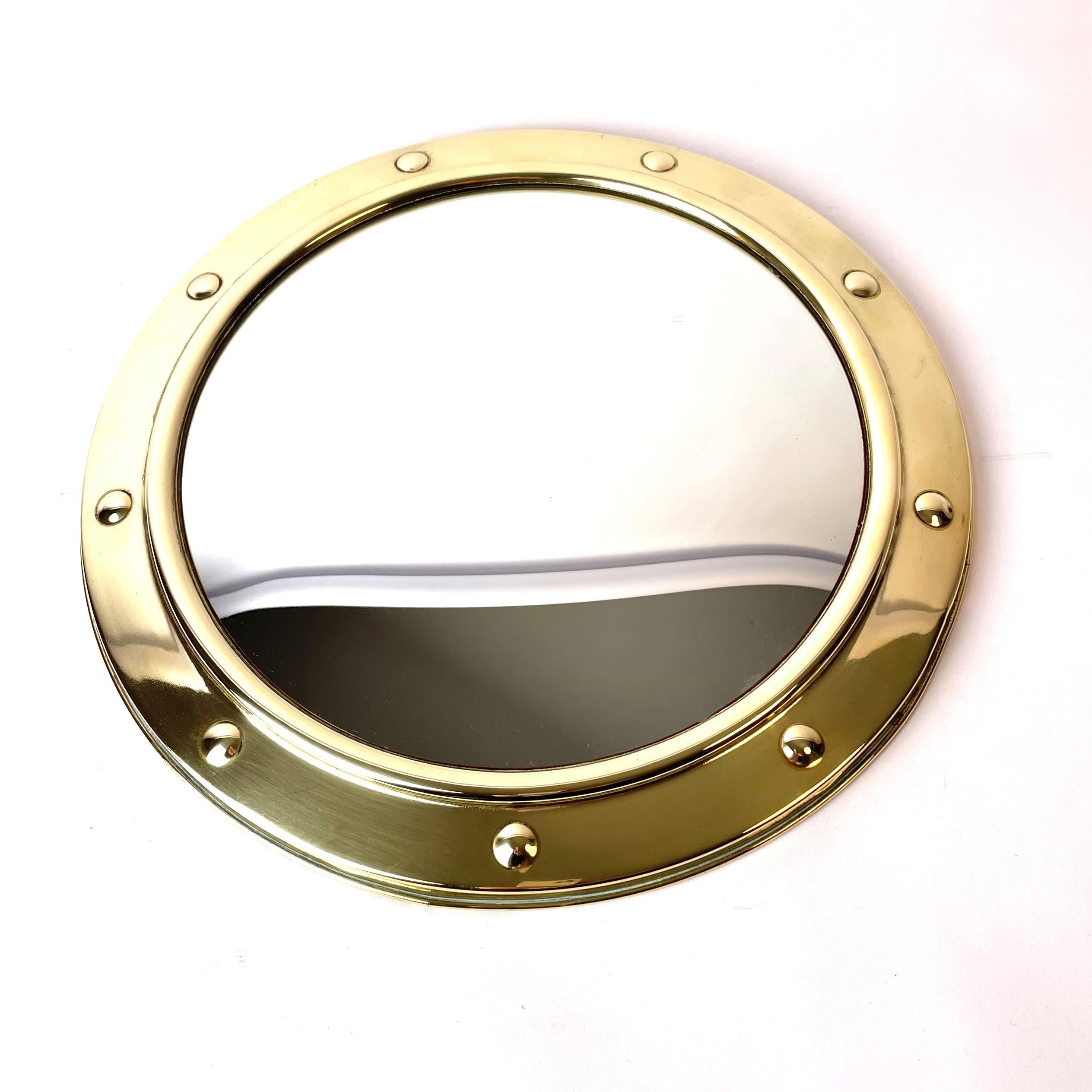 A beautiful mid-20th century porthole convex wall mirror in brass, made by Linton in England, probably in 1940s-1950s.

The mirror is in good condition, but has a small dent on the underside of the mirror (see picture). The dent is not visible