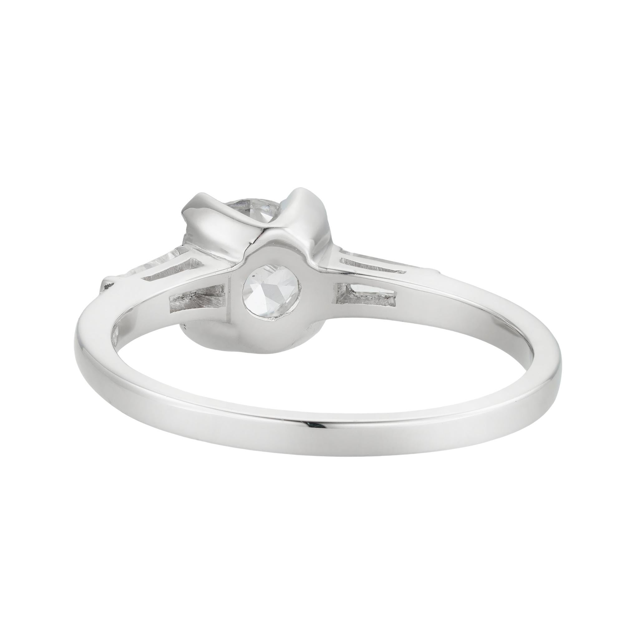 A mid-20th century single stone diamond ring, the old European cut diamond weighing 0.91 carats, accompanied by De Beers report stating to be of E colour and VS2 clarity, four claw set between two tapered baguette-cut diamonds estimated to weigh a
