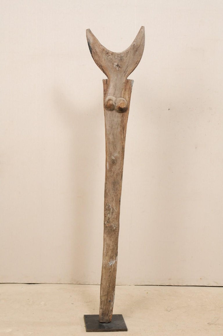 An early to mid-20th century Toguna support post from the Dogon Tribe of Mali, on custom metal stand. This West African hand carved wooden bean was originally used for supporting the 