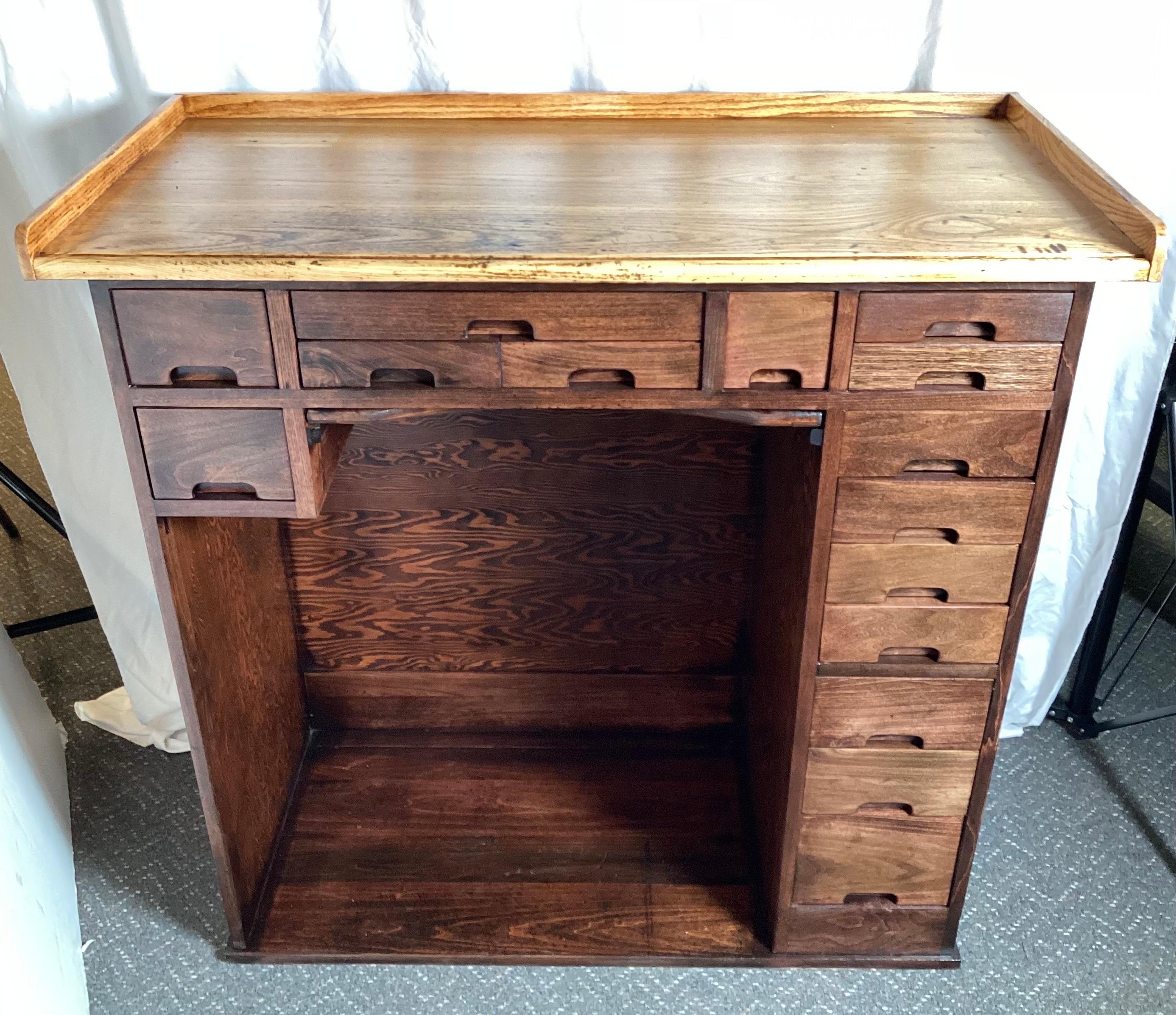 A beautifully made and well preserved Jewelers cabinet. The oak top with darker hardwood body with 15 drawers plus a catch tray. Great condition and very rare and unique.