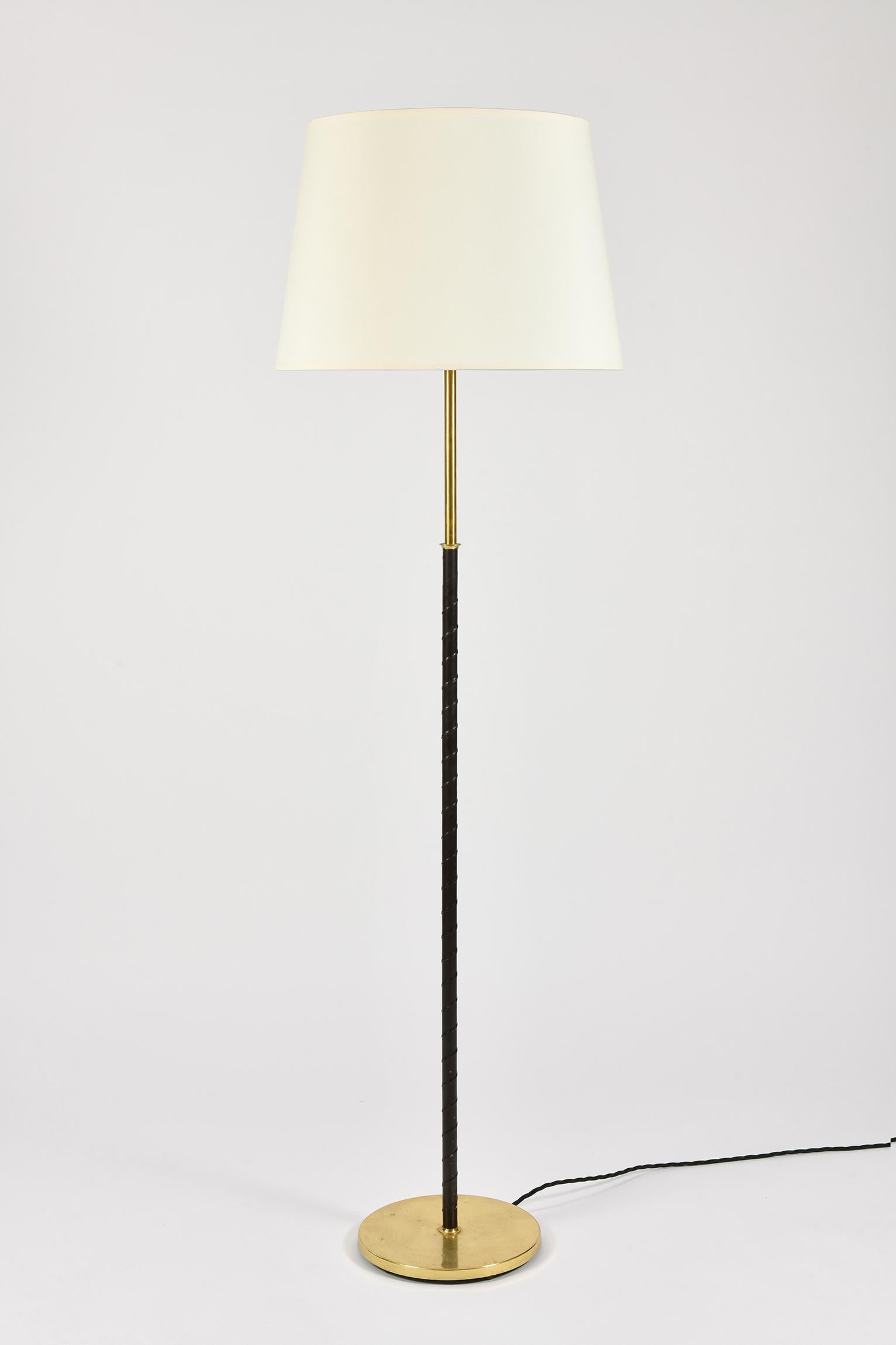 A brass and black leather floor lamp, with a bespoke ivory tapered shade
Sweden, circa 1970
The shade is included in the measurements.