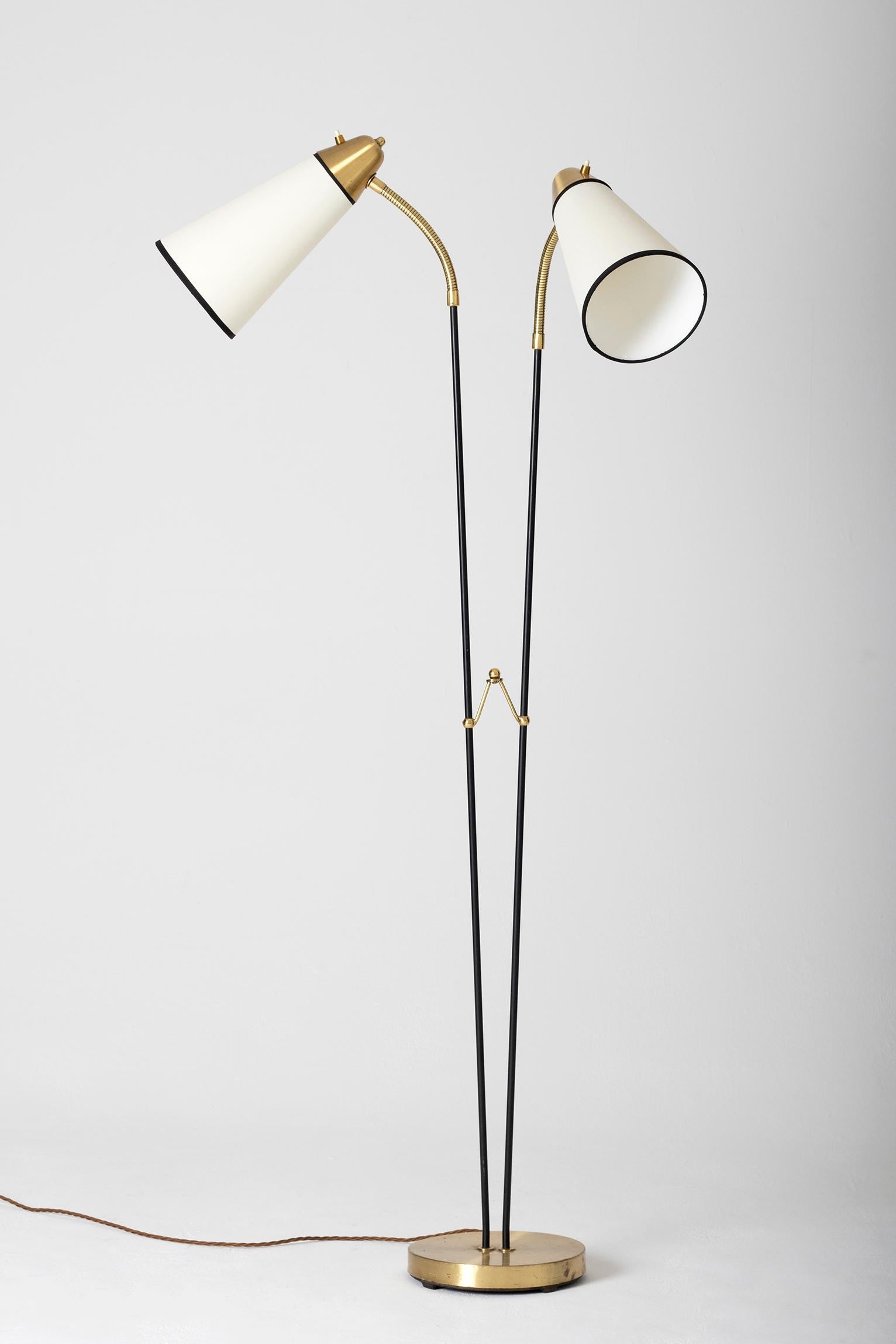 A brass and black enameled iron two-armed floor lamp, with bespoke shades
Sweden, third quarter of the 20th century.