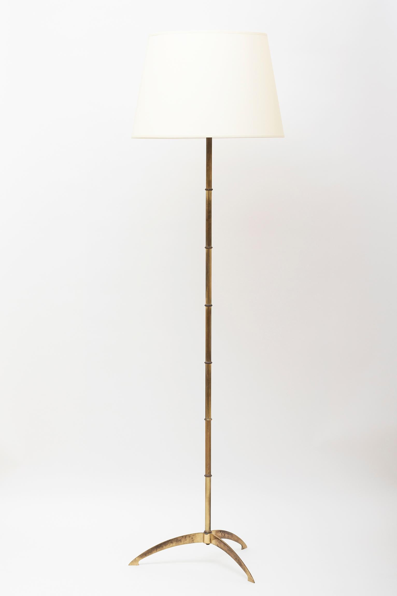 A brass floor lamp, the reeded stylized bamboo stem on a bowed tripod base.
France, circa 1950
Measures: With the shade: 161 cm high by 46 cm diameter
Lamp only: 135 cm high.