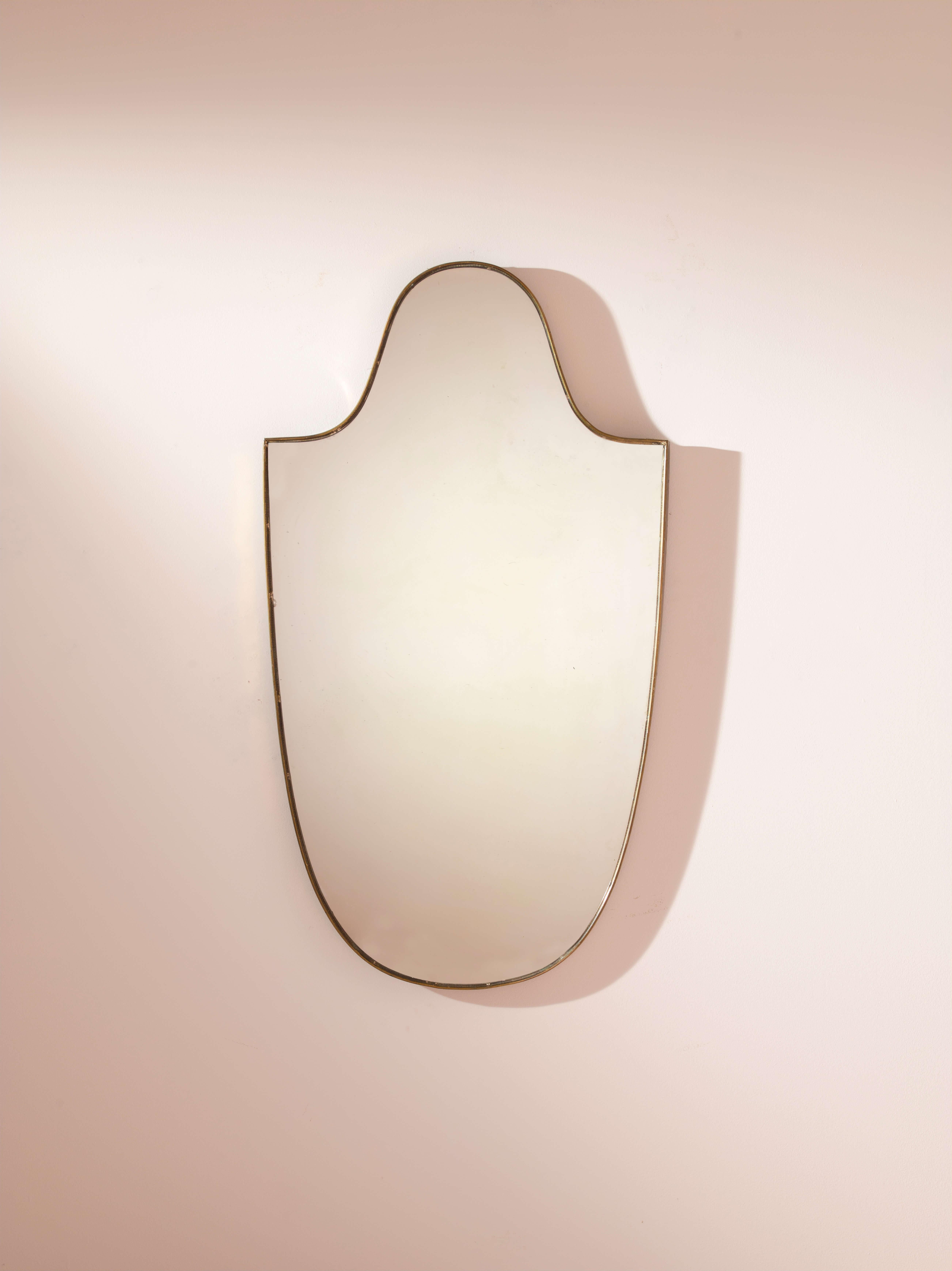 Un élégant miroir en laiton avec un cadre en laiton poli et un verre en cristal miroitant, artisanat italien, années 1950.

Le miroir, un objet d'allure intemporelle, un symbole de vanité et un accessoire de design capable d'imprégner de caractère