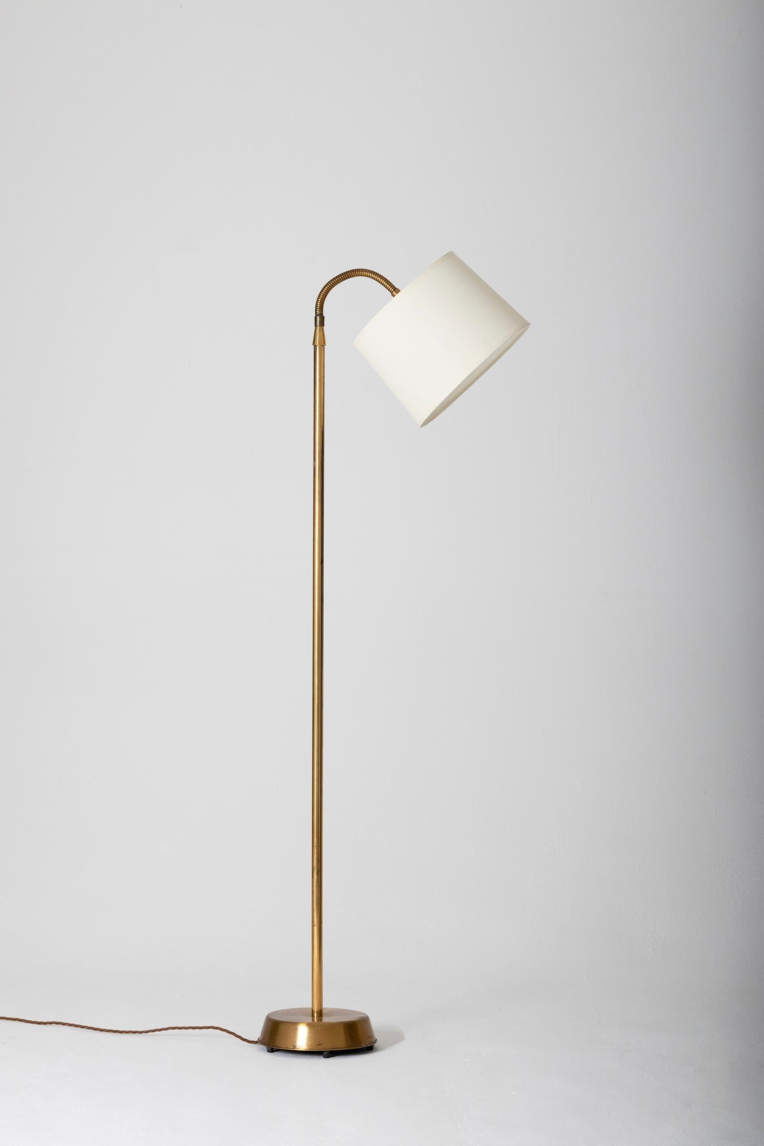 A brass reading floor lamp, with an orientable brass gooseneck and bespoke off-white shade.
Sweden, circa 1950-1975.
