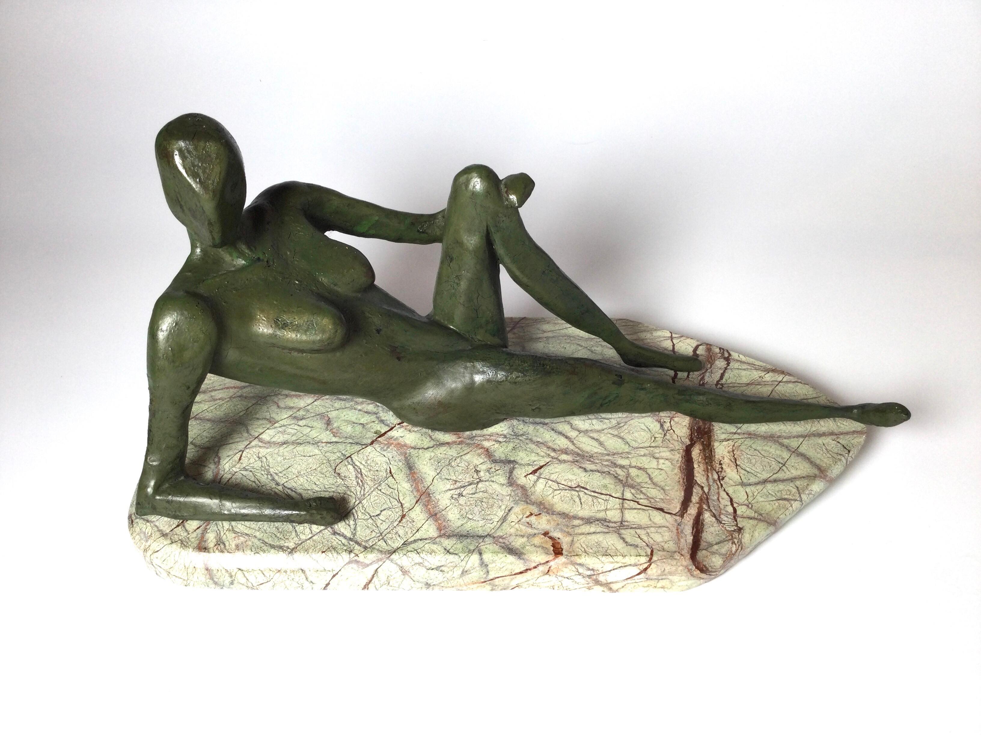 The hand painted plaster sculpture on tan marble base of a reclining woman in cubits style. The hard dense plater with an aged green patinated painted finish.