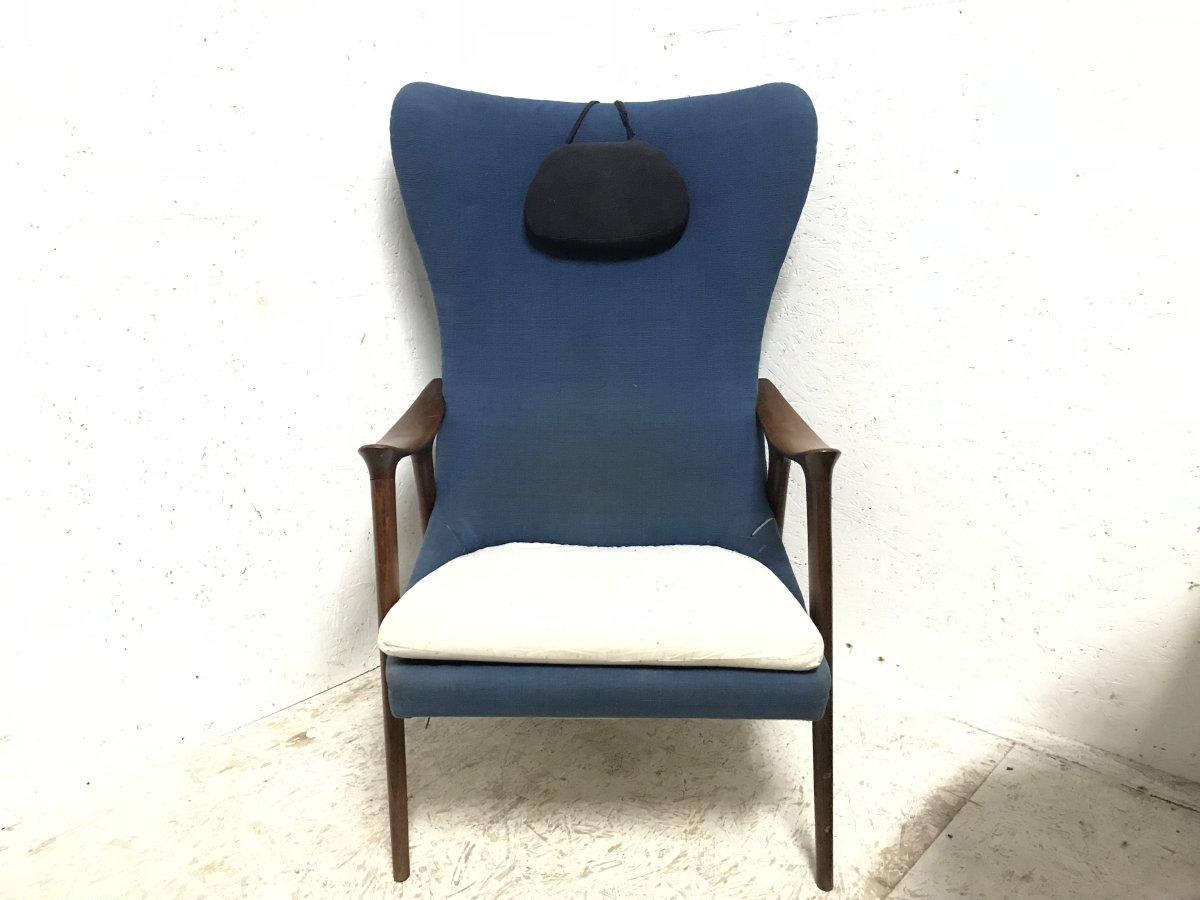 A good quality Mid-Century Modern Scandinavian upholstered egg chair in the style of Arne Jacobson with teak shaped sculptural arms on scissor style legs, in blue with a weighted adjustable head rest pad and a loose white cotton seat pad.