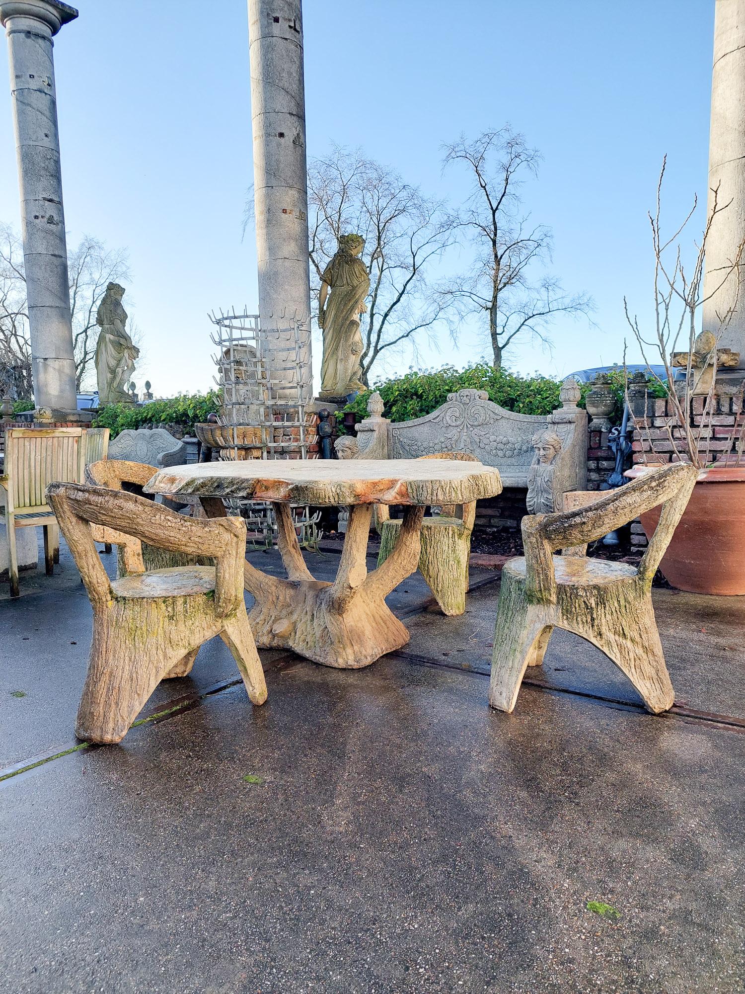 A mid-century faux bois stone garden table and chairs. Faux Bois (false wood) refers to the artistic imitation of wood and wood grain. This rustic composite garden set consists of four chairs and a table, each with a natural relief of tree stump and