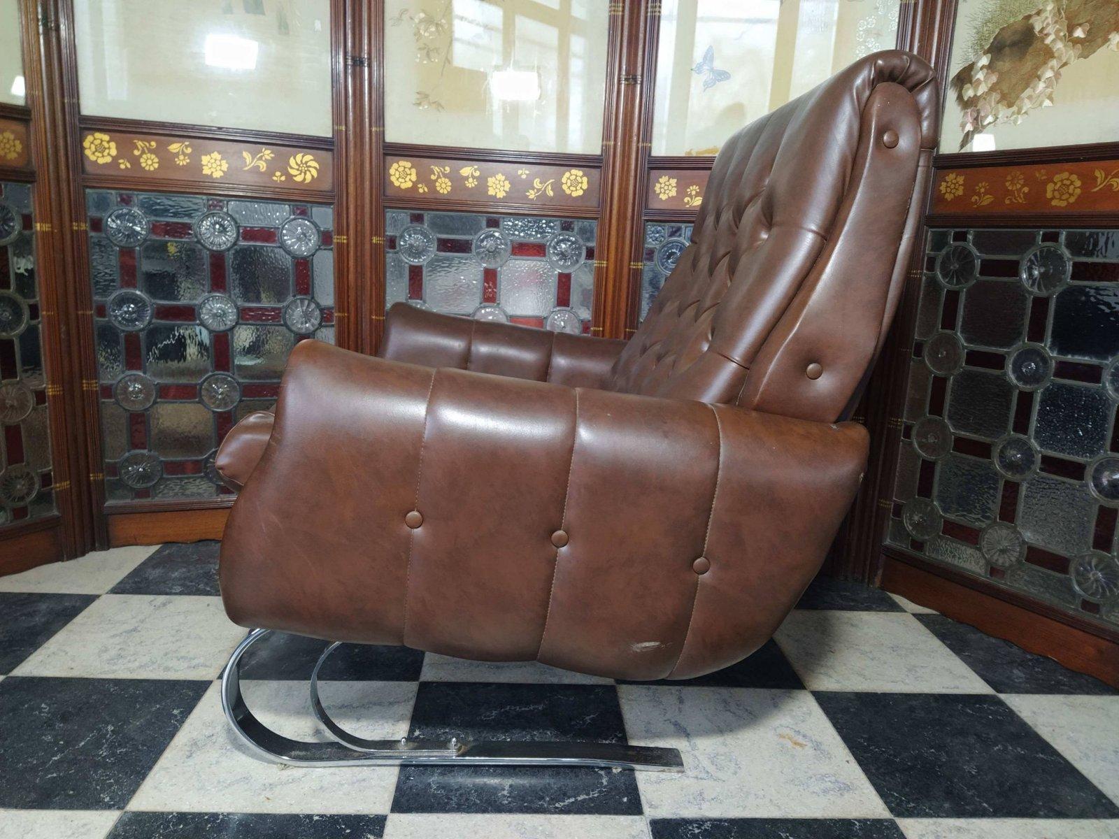 A Mid Century Modern French Cantilever Armchair with the original brown vinyl upholstery in really good condition. The chrome cantilever base gives it a stylish look and a gentle relaxing movement when one sits in it or rocks it.